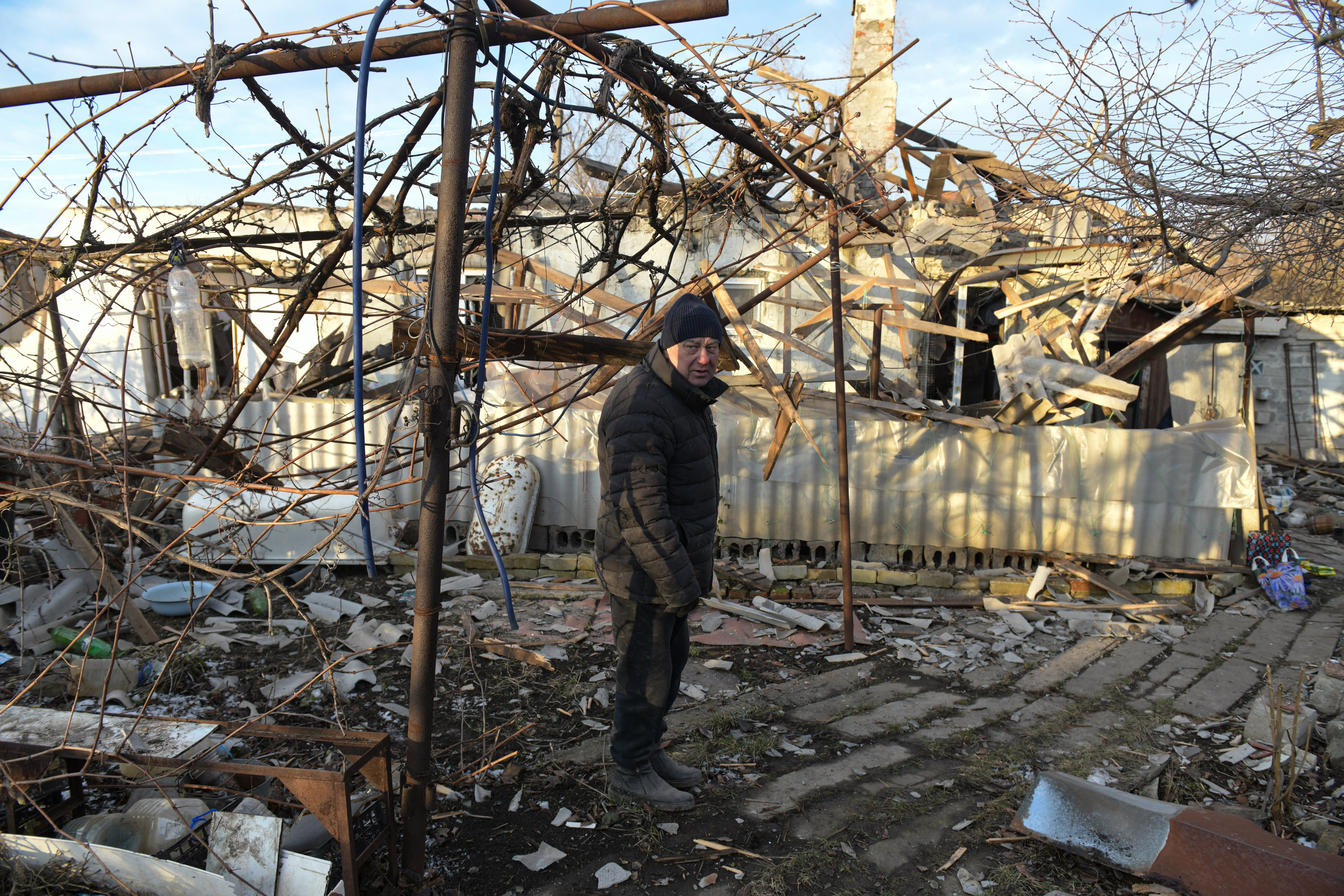 A local resident stands in the yard of his destroyed house following shelling in Makiivka (Makeyevka) in the Donetsk region