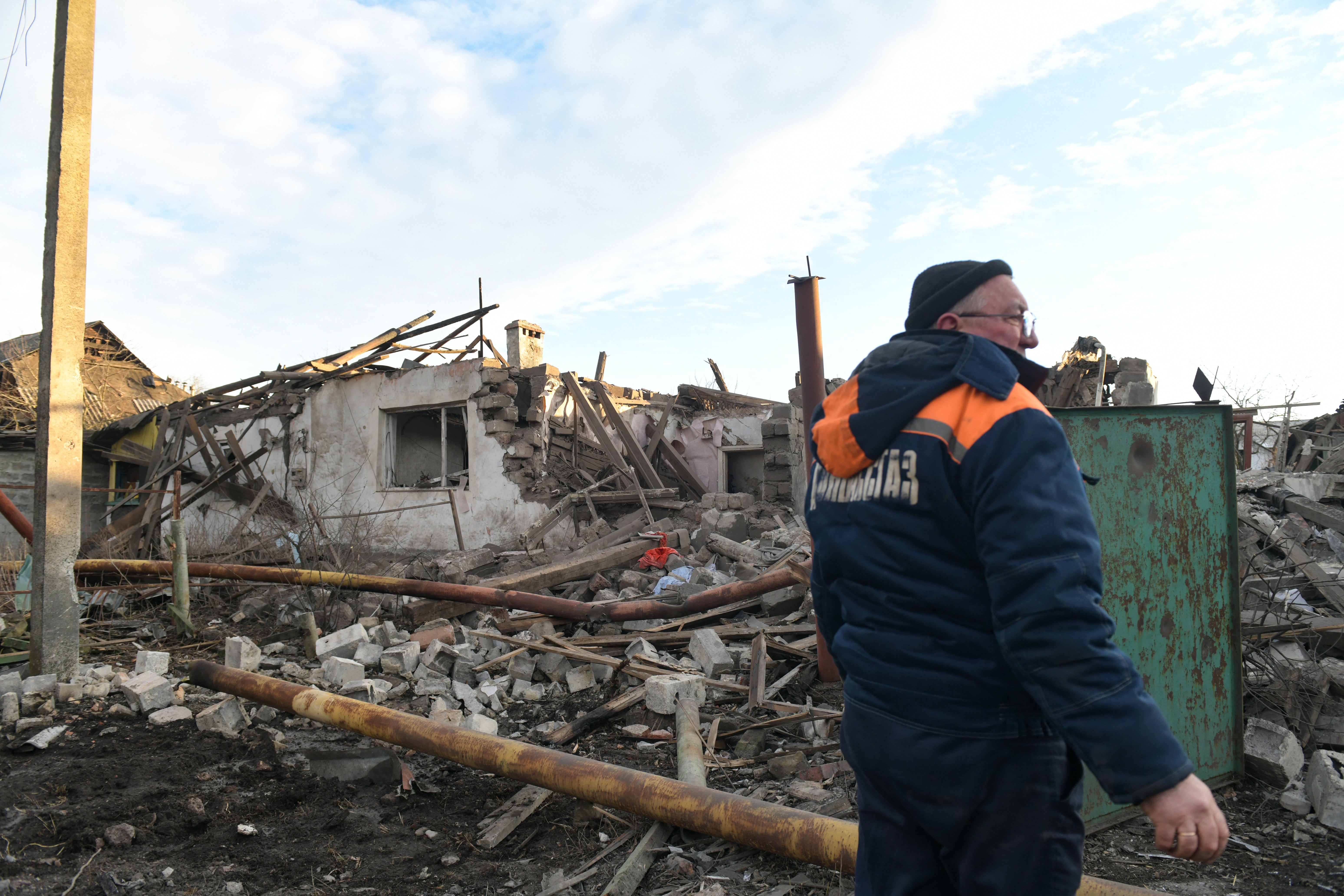 A worker stands in front of a destroyed house following shelling, which local officials called a Ukrainian military strike, in Makiivka a Russia-controlled Ukrainian territory