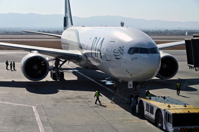 <p>Ground staff stand next to the Pakistan International Airline aircraft ahead of its takeoff for Paris at the Islamabad International Airport </p>