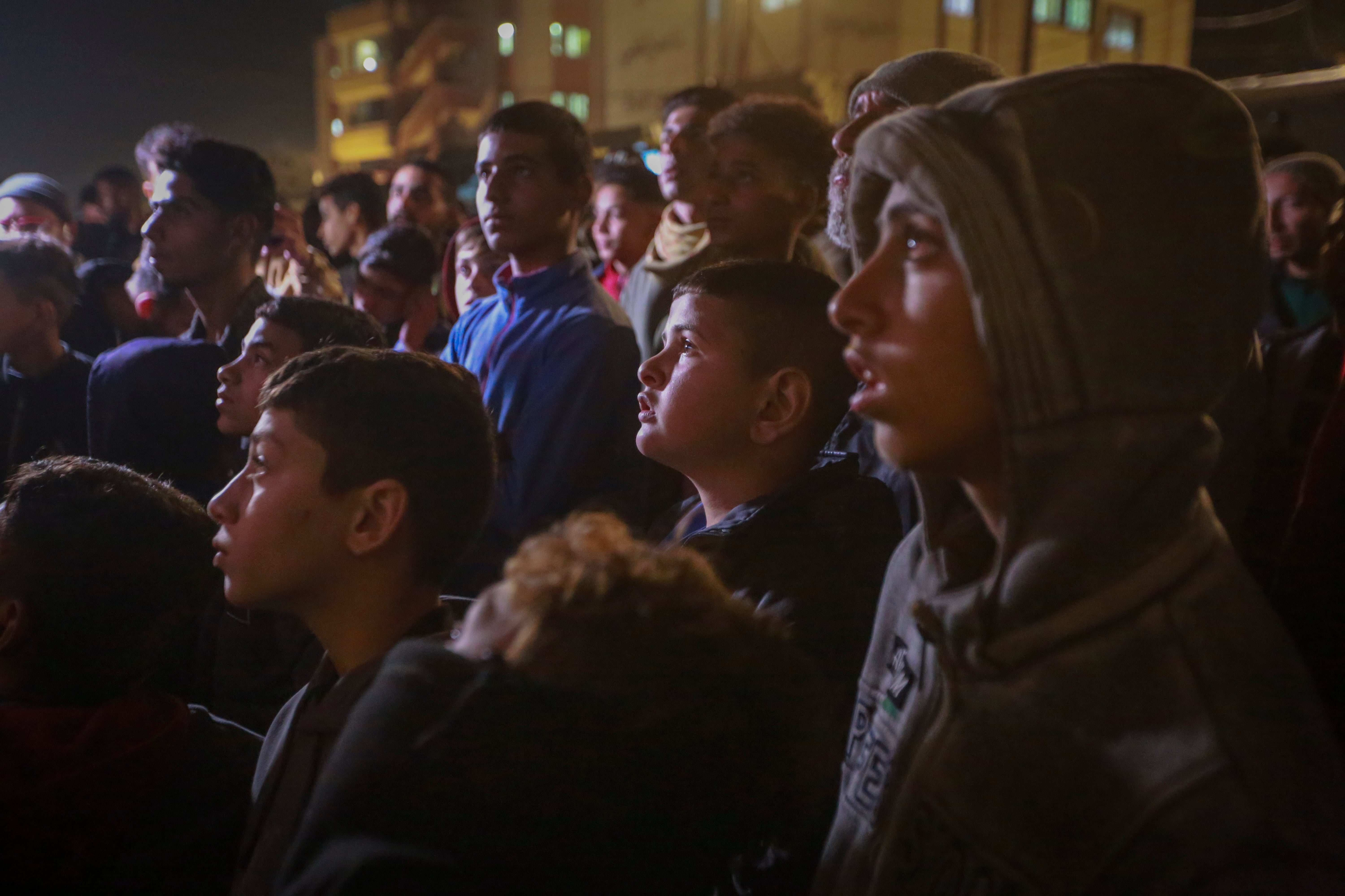 Palestinians watch TV as they await the announcement of the ceasefire deal between Hamas and Israel in Khan Younis