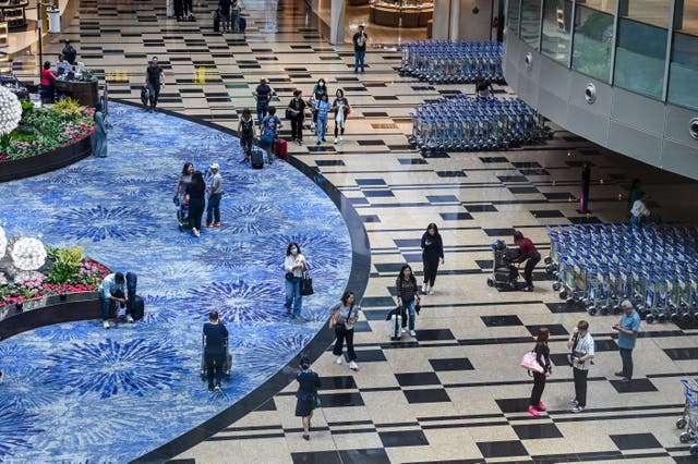 <p>File. Passengers walk through the departure transit hall at Singapore Changi airport</p>