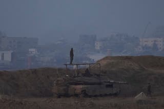 An Israeli soldier stands on a tank on the border with Gaz