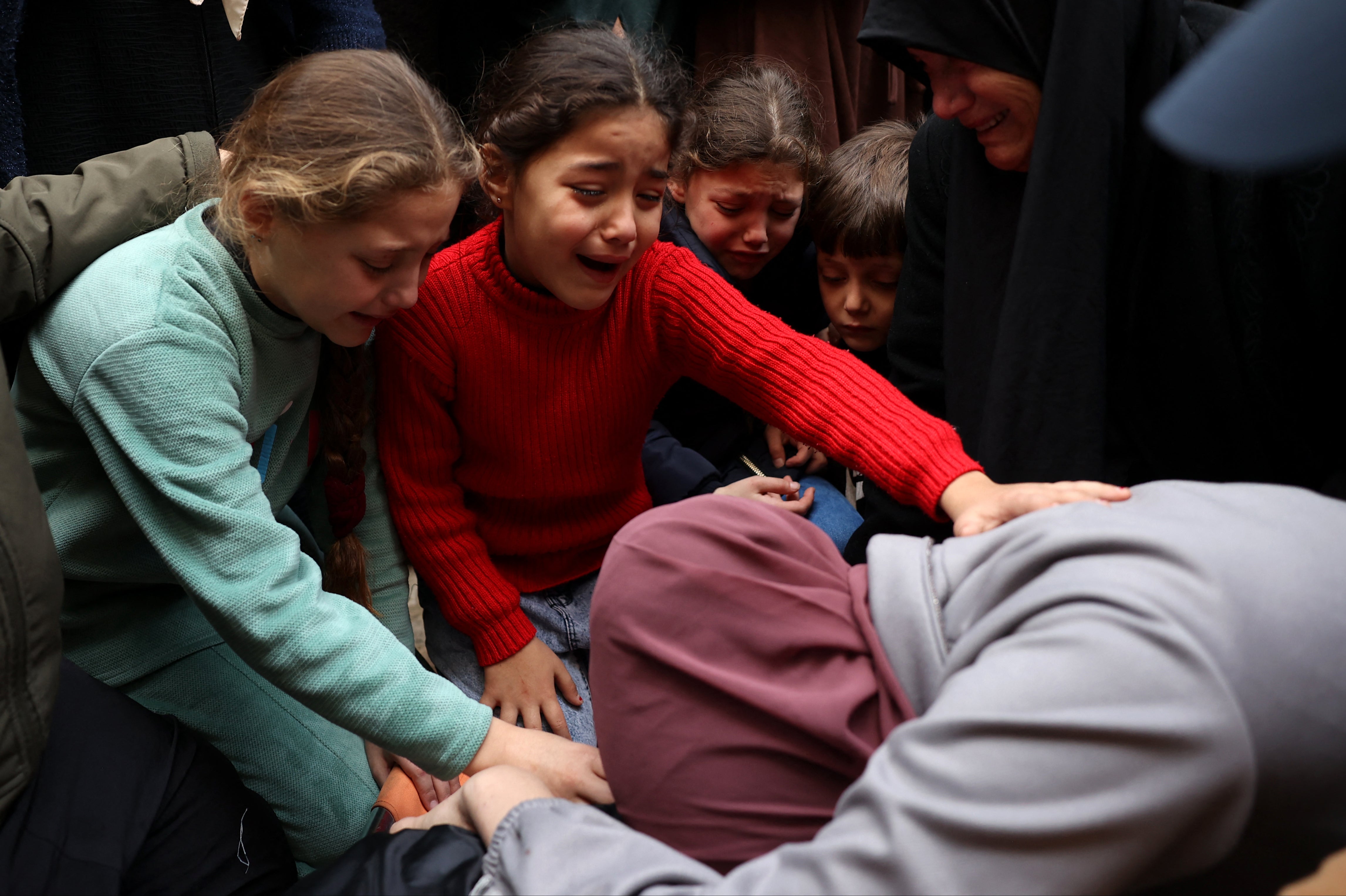 The daughters and wife of Palestinian Ahmed Alrawi, killed the previous day in an Israeli strike, mourn during his funeral in Jenin's refugee camp