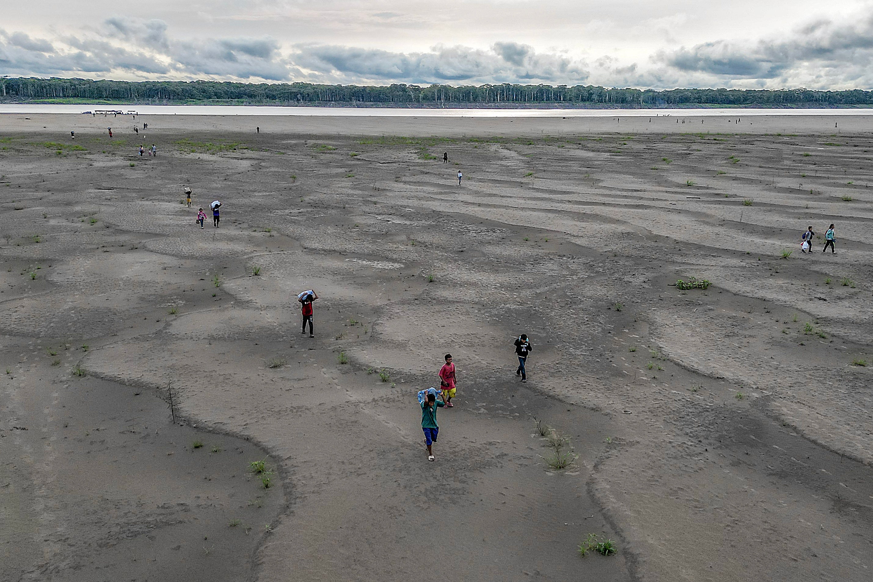 An aerial view shows Yagua Indigenous people carrying water and other goods due to the low level of the Amazon river at Isla de los Micos in Colombia last October. Researchers have said that climate extreme last year contributed to extensive drought in the region