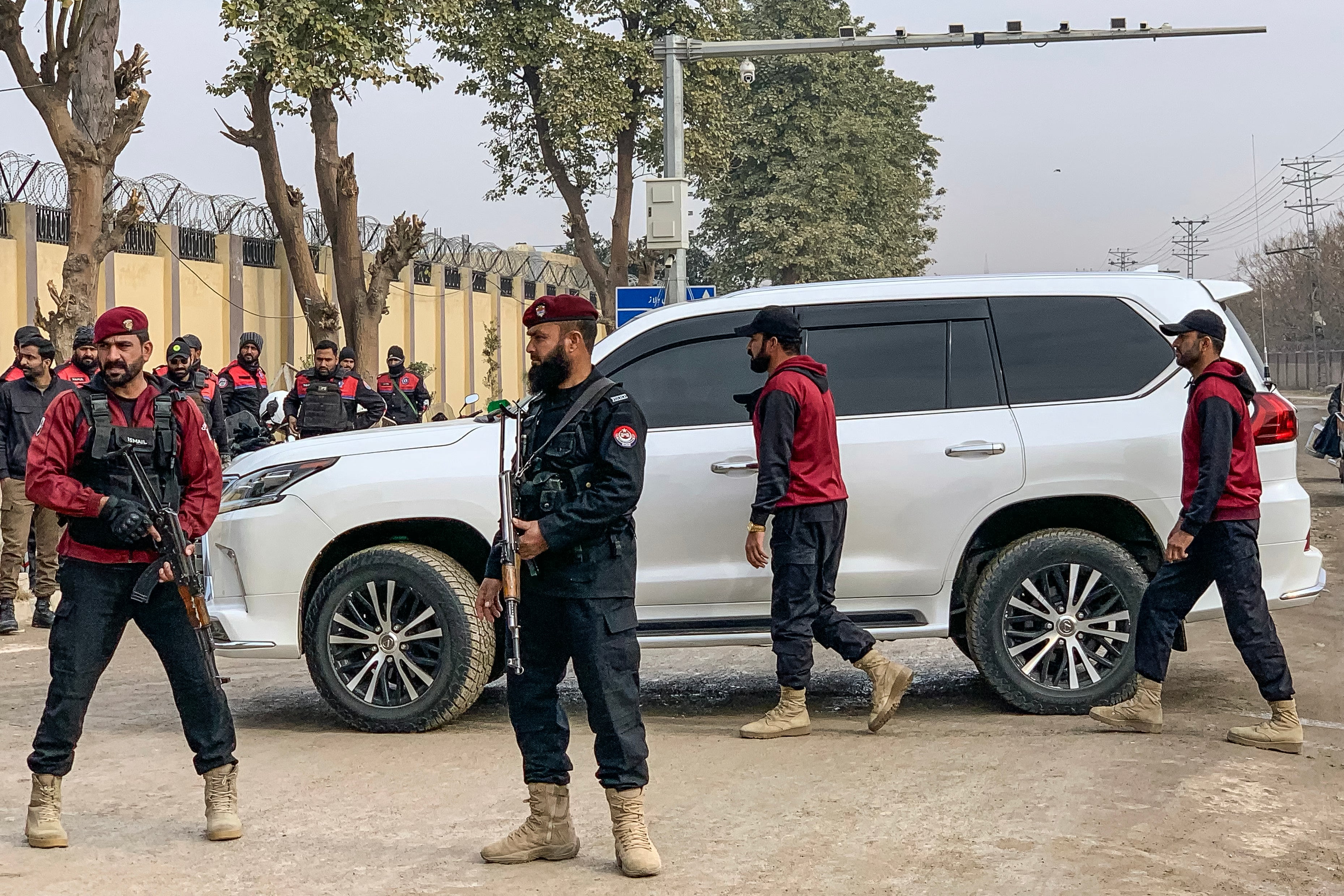 Policemen stand guard around a vehicle carrying Bushra Bibi outside the Adiala prison in Rawalpindi