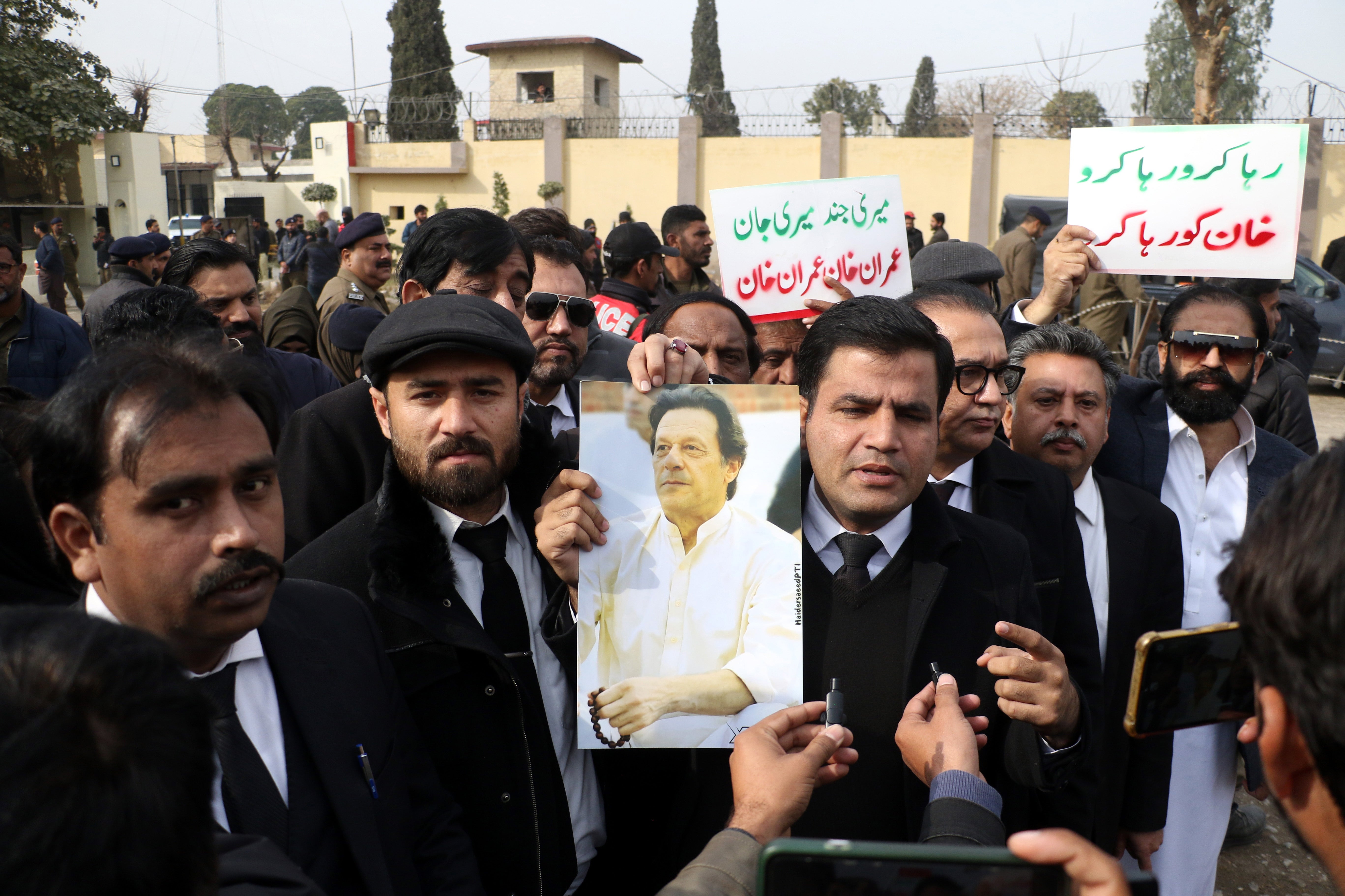 Supporters of the opposition party Pakistan Tehreek-e-Insaf (PTI) hold a picture of former prime minister Imran Khan, after the hearing on Friday