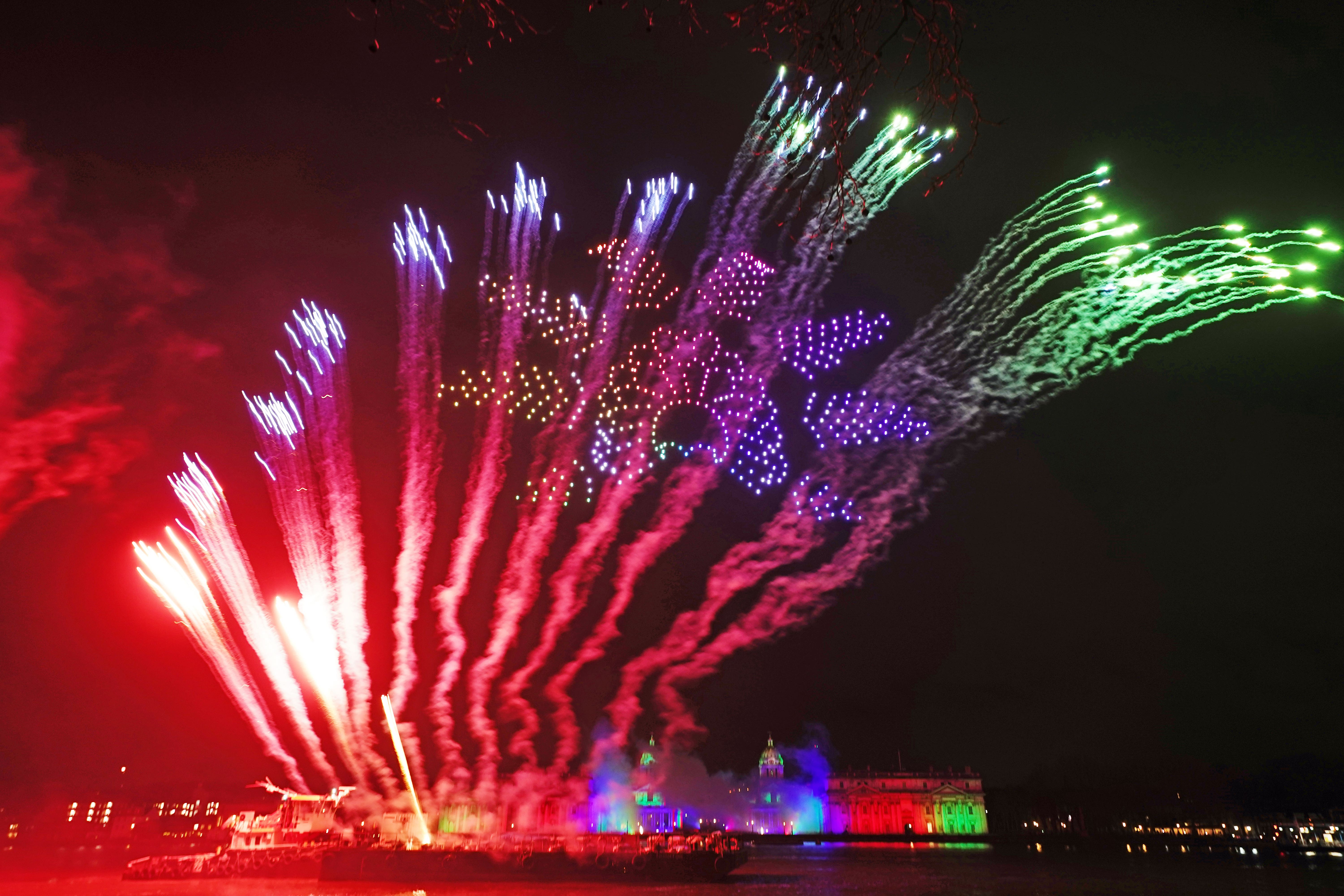 Drones and fireworks illuminate the night sky over the Old Royal Naval College in London (Aaron Chown/PA)