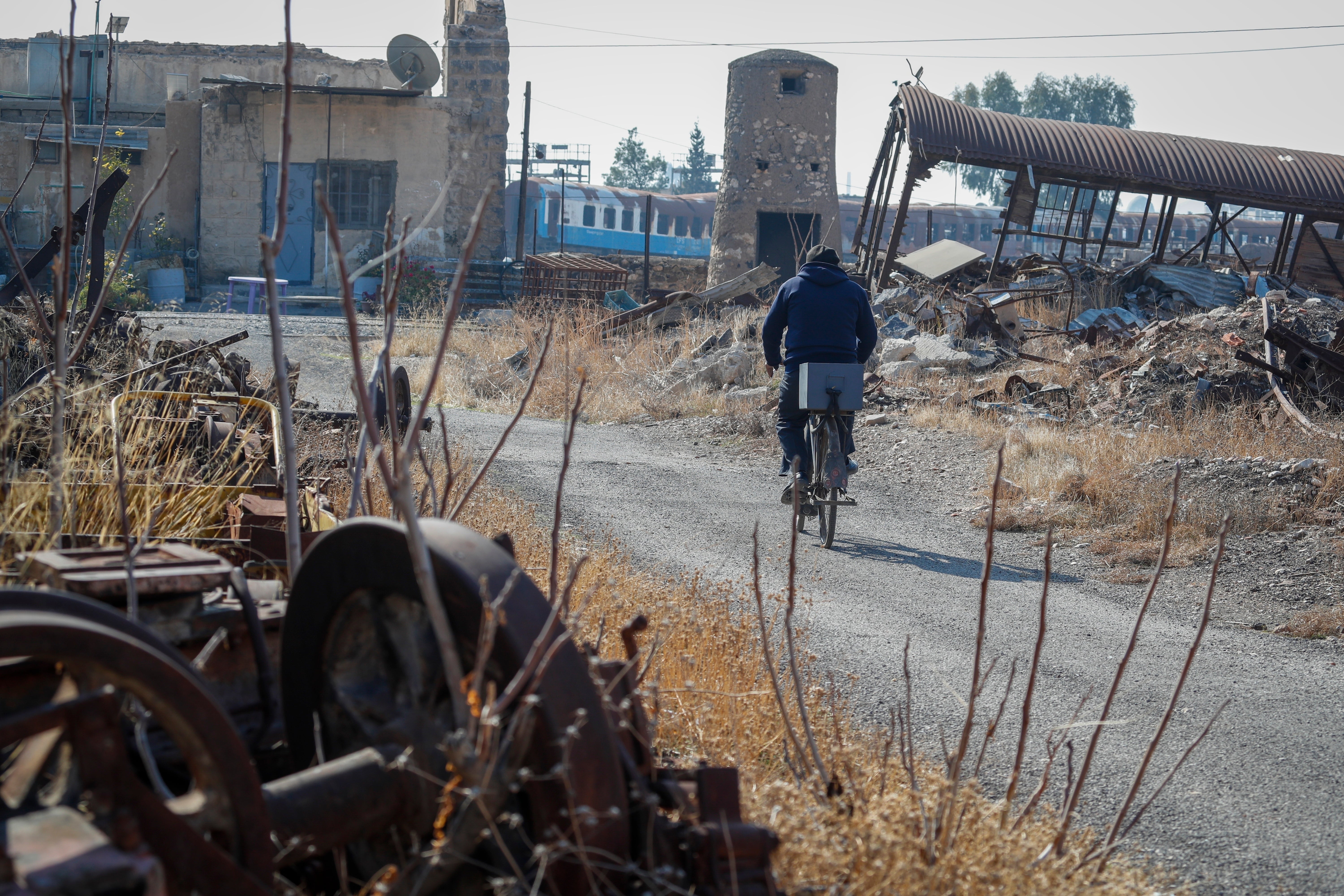 O operador ferroviário Mazen Malla anda de bicicleta pela estação ferroviária Qadam, que foi danificada durante a guerra entre as forças rebeldes e as forças do presidente deposto Bashar Assad, em Damasco, Síria, segunda-feira, 13 de janeiro de 2025. (AP Photo / Omar Sanadiki)