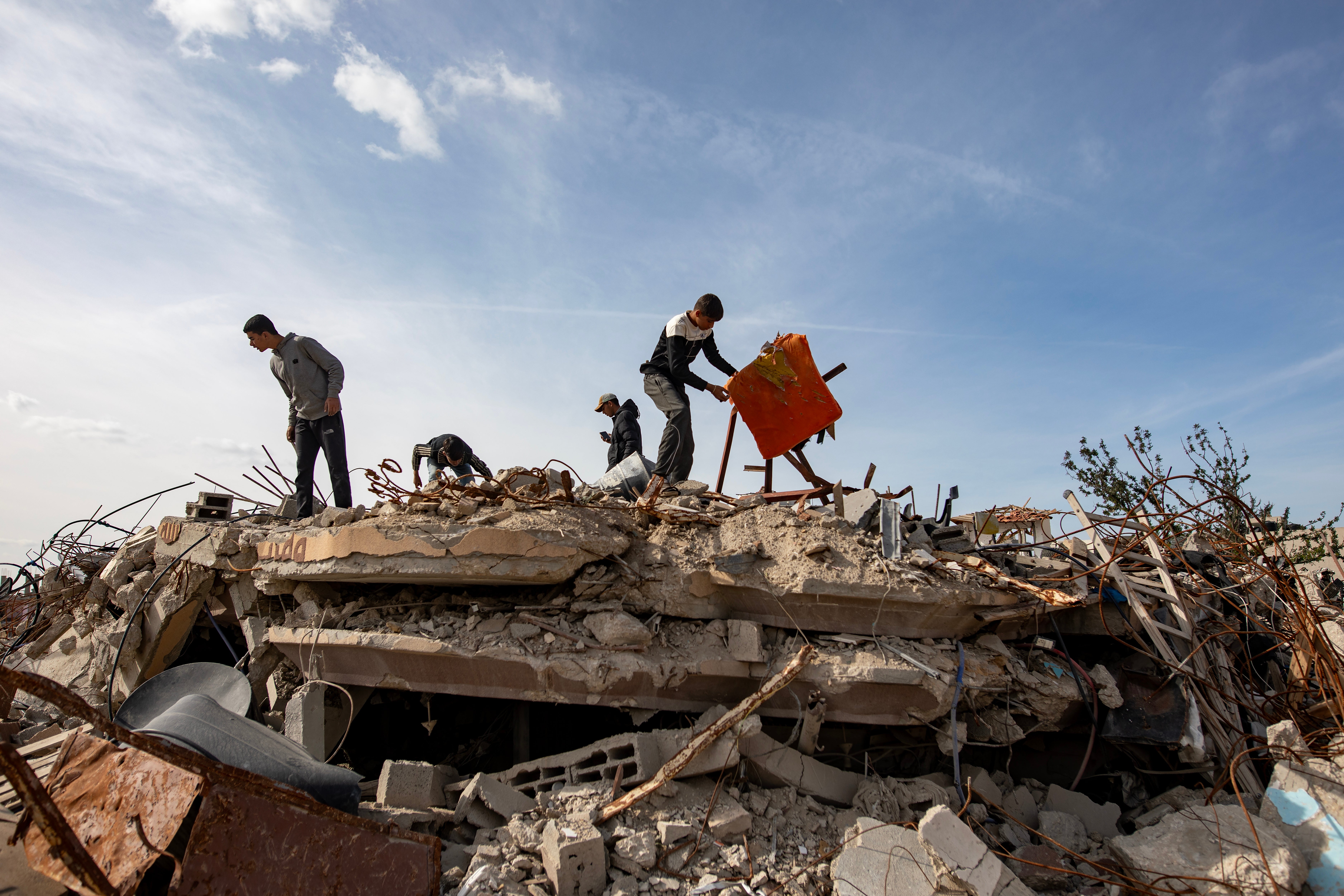 Internally displaced Palestinians inspect the rubble of the building where late Hamas leader Yahya Sinwar was reportedly killed