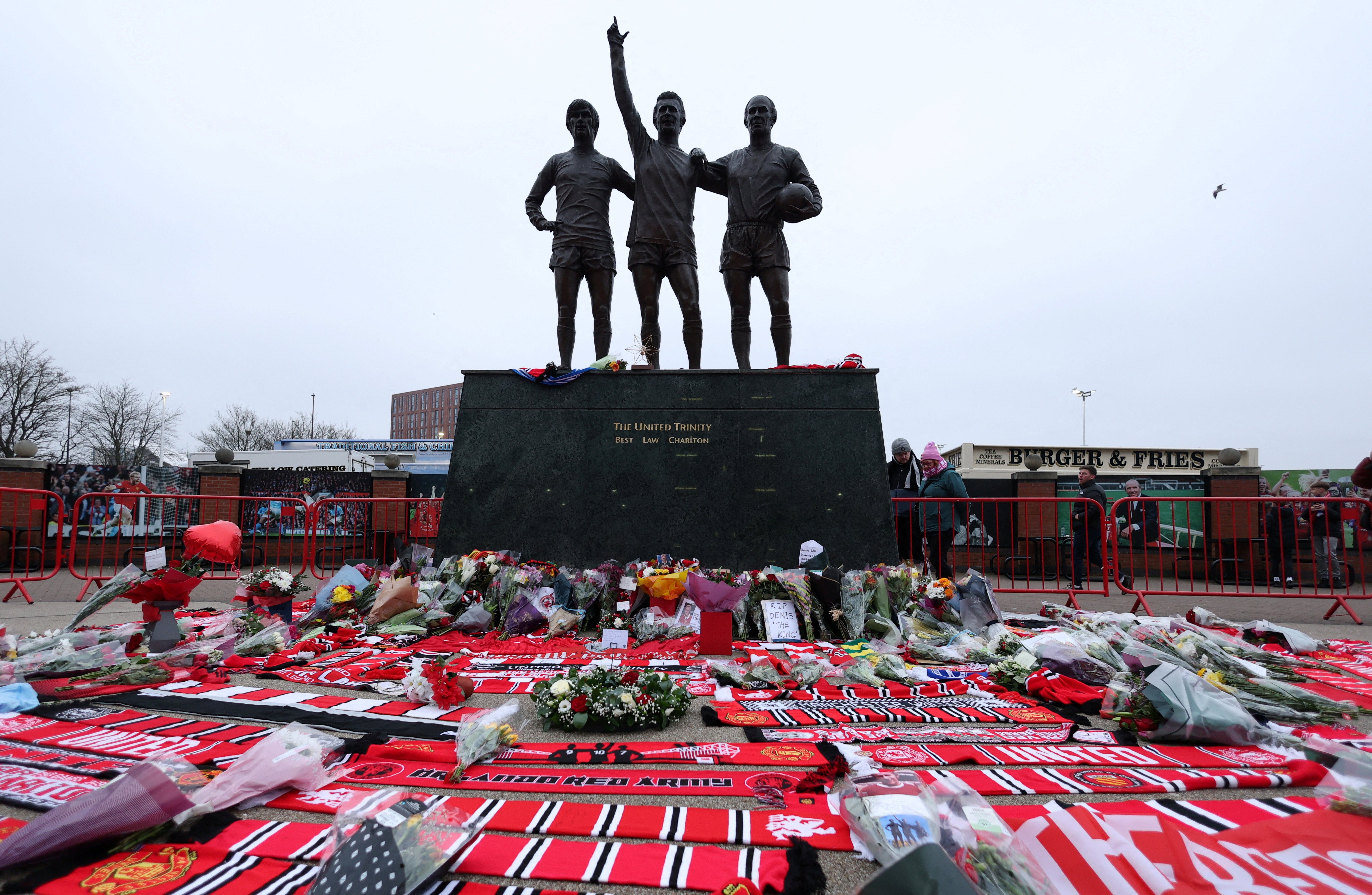 Flowers are laid in front of the Trinity statue in memory of former Manchester United player Denis Law