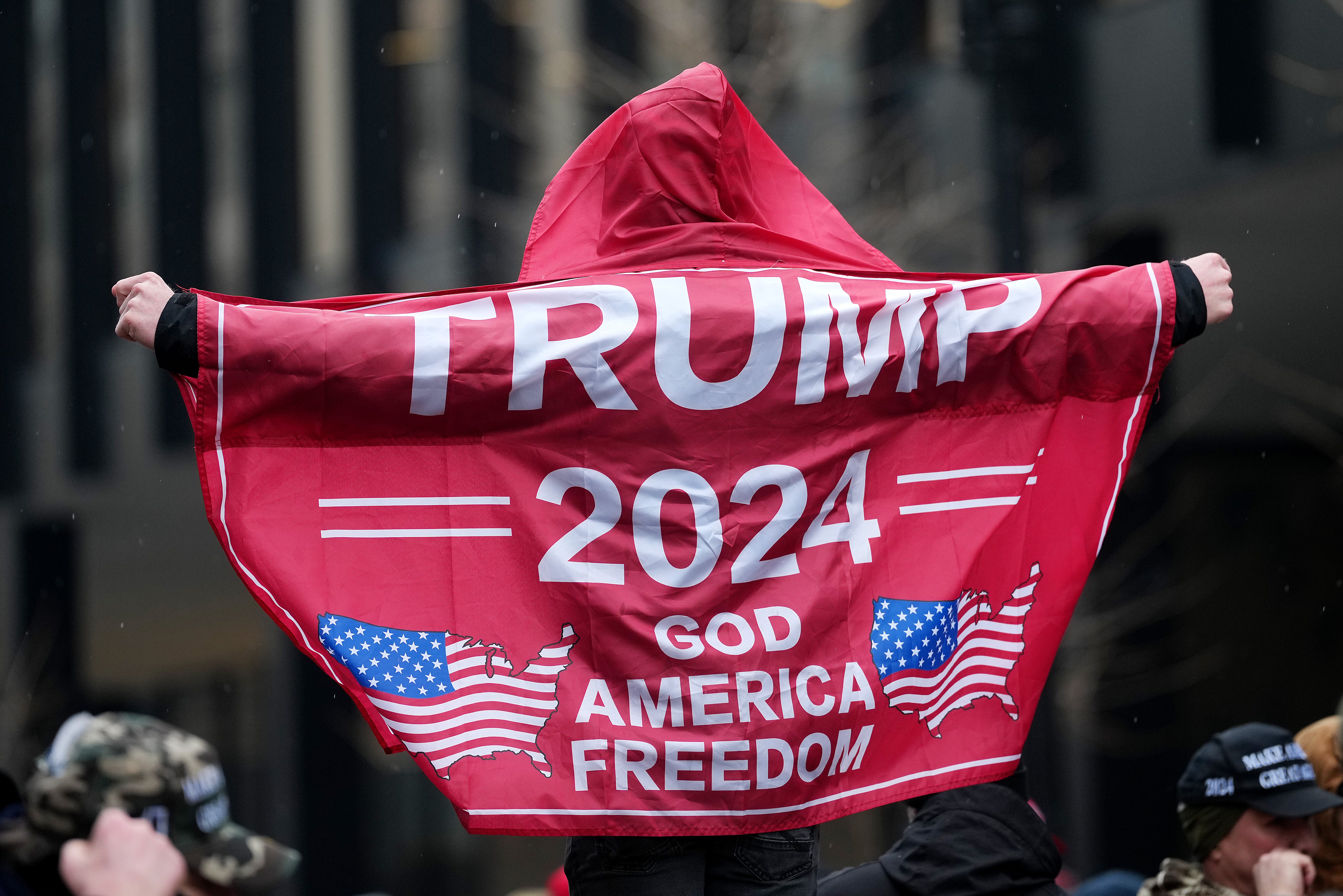 A supporter waves a Trump flag while waiting in line for his victory rally in Washington, D.C.