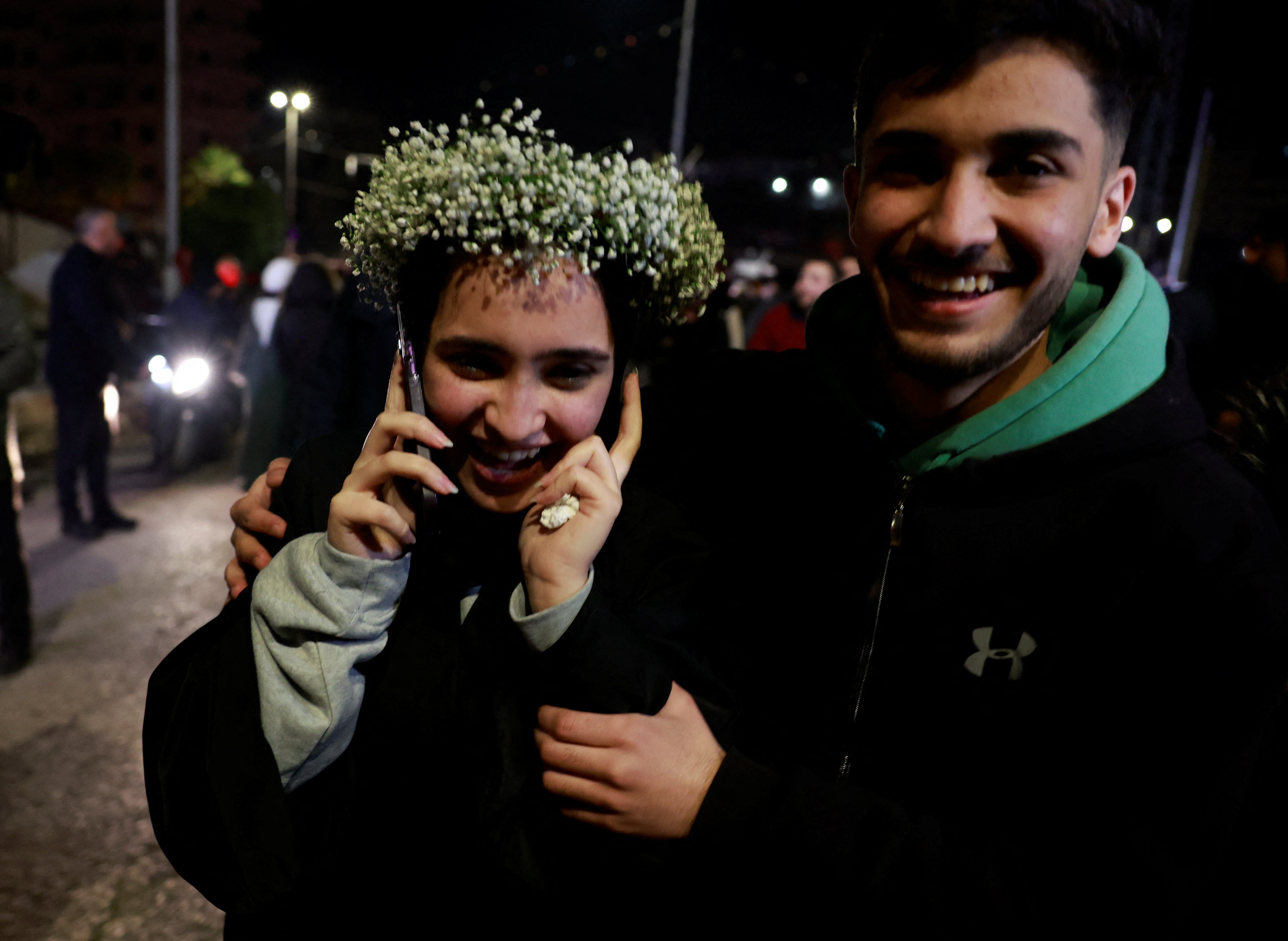 A freed Palestinian prisoner speaks on a phone after being released from an Israeli jail