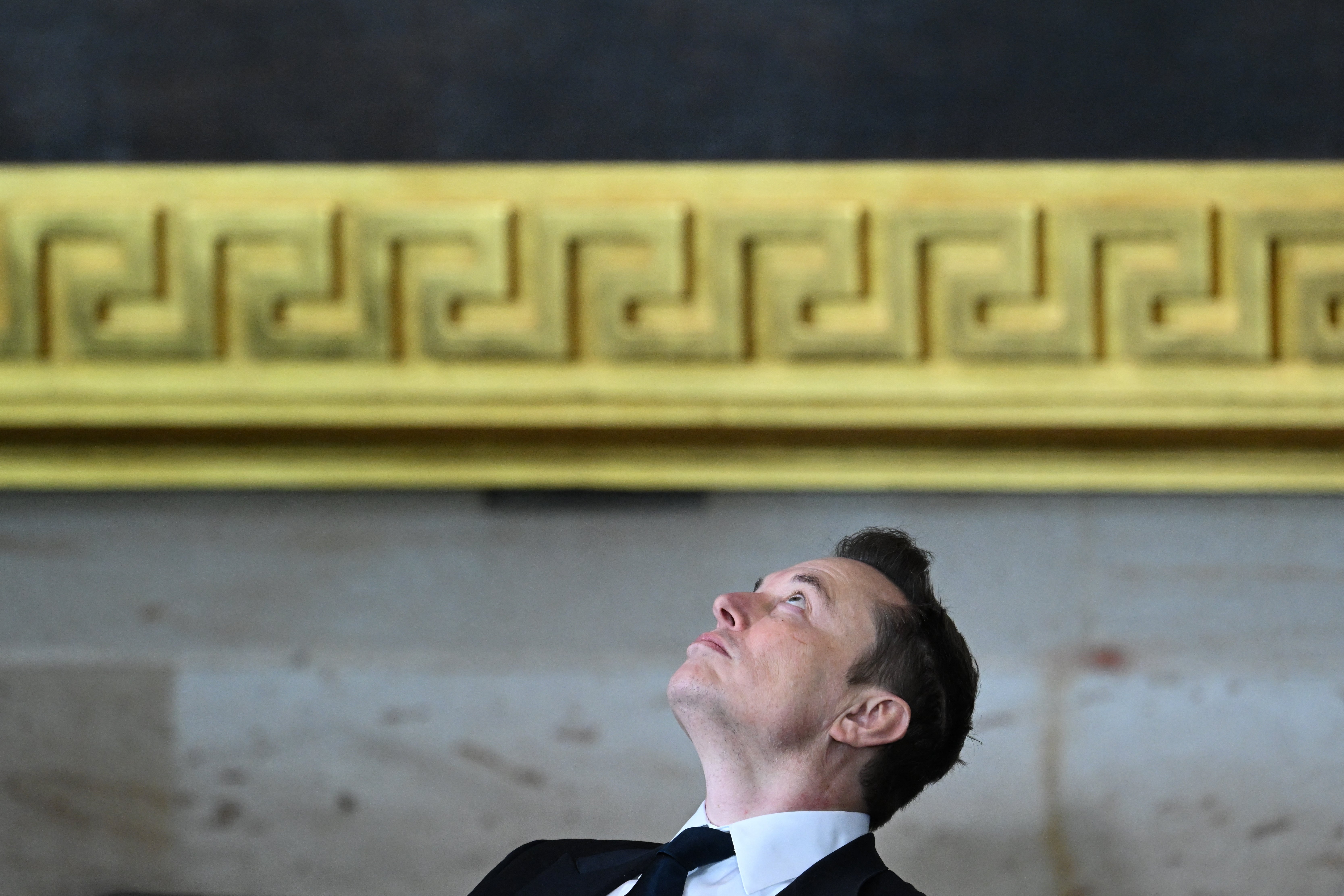 Elon Musk, CEO of Tesla and SpaceX, looks up as he sits at the inauguration.