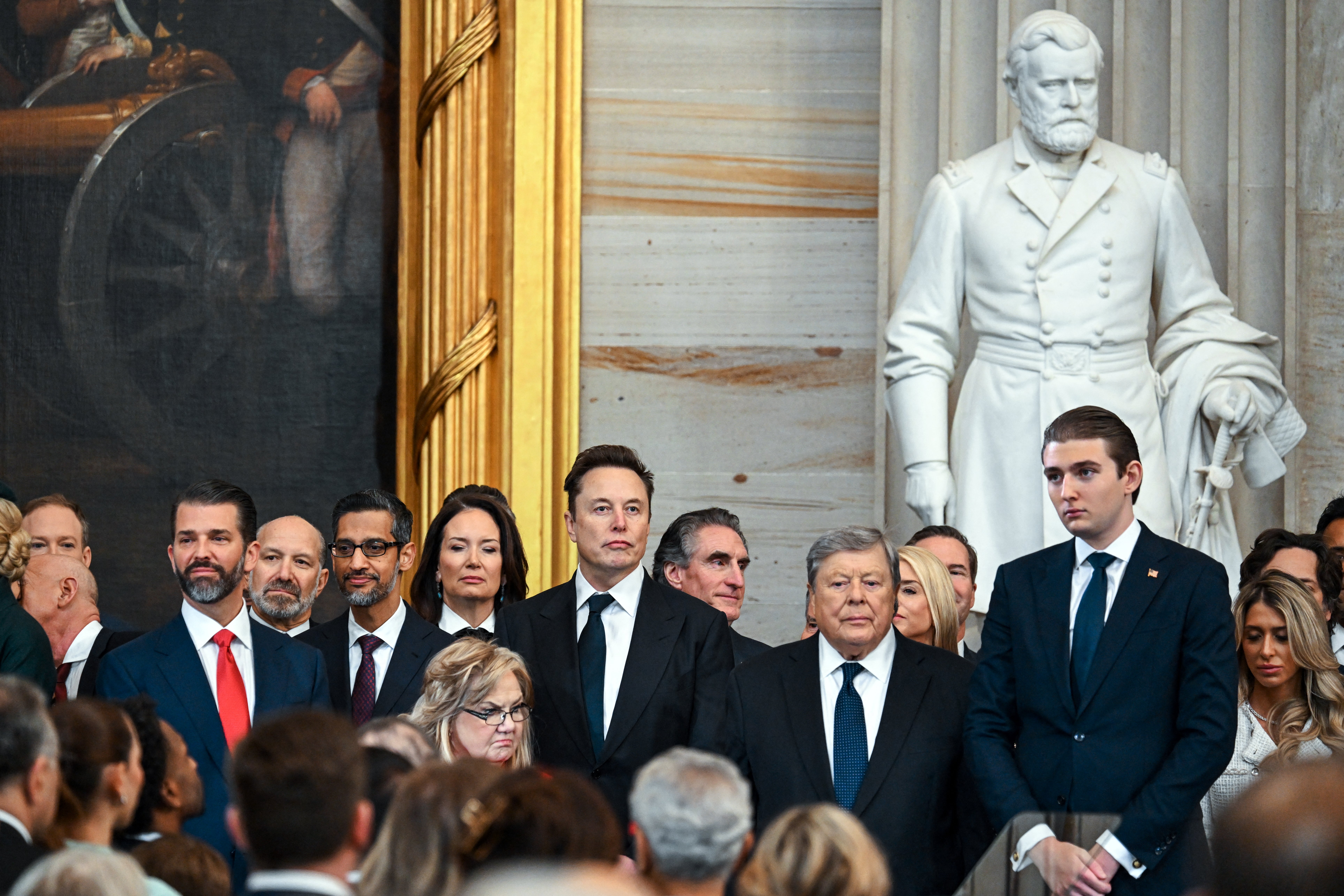 Musk stands next to Baron Trump and Don Trump Jr. during the inauguration