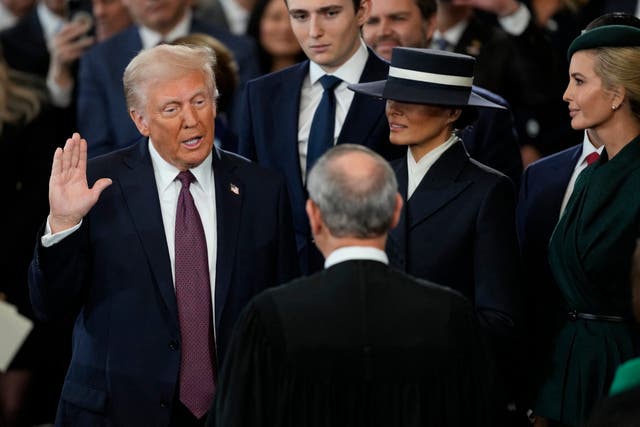 <p>Donald Trump is sworn in as the 47th president of the United States by Chief Justice John Roberts as Melania Trump holds the Bible in the US Capitol Rotunda</p>