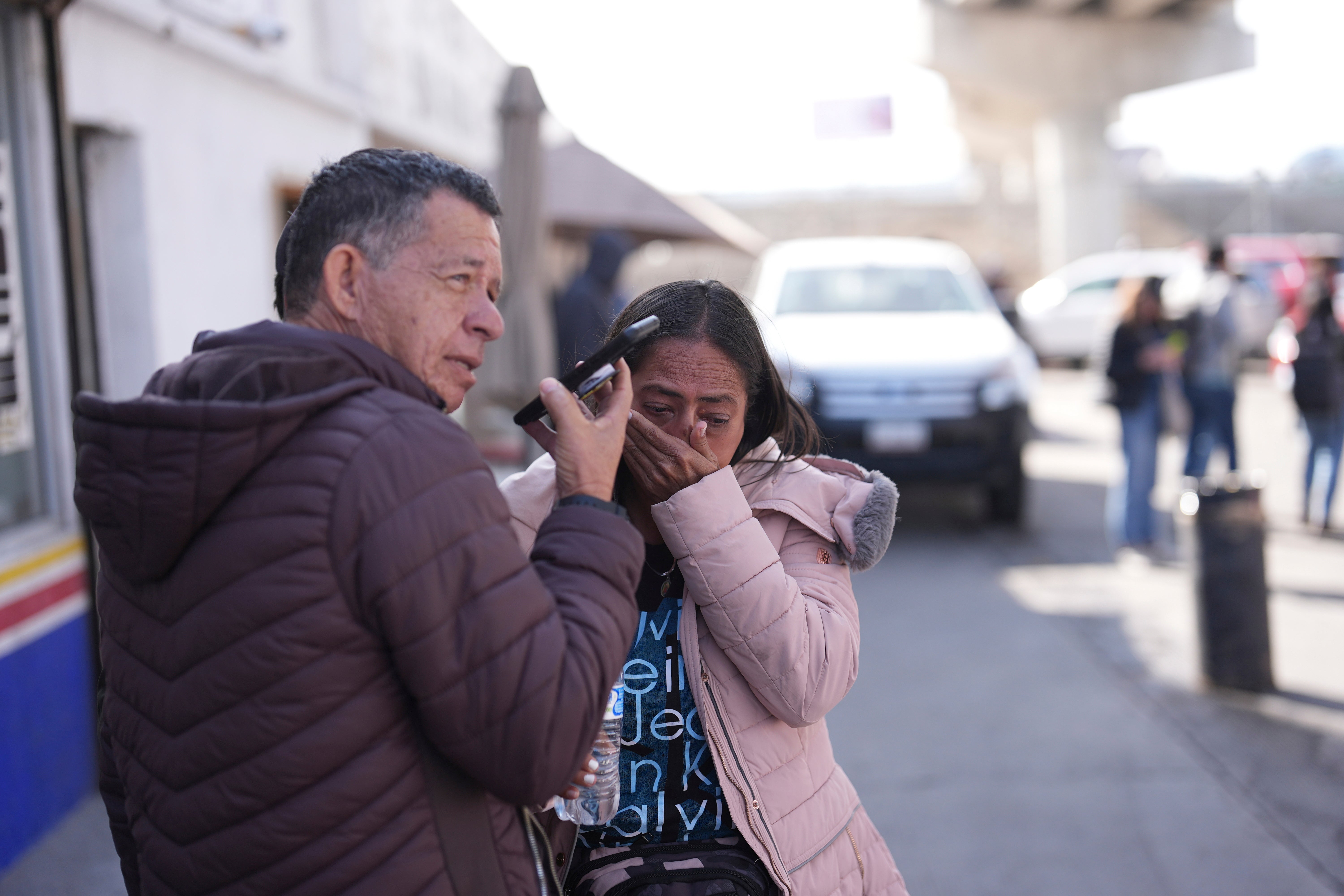 Marcela Medina and her husband Enrique Corea of Venezuela react to seeing that their appointment was canceled on the CBP One app as they wait near the border crossing in Tijuana, Mexico on January 20