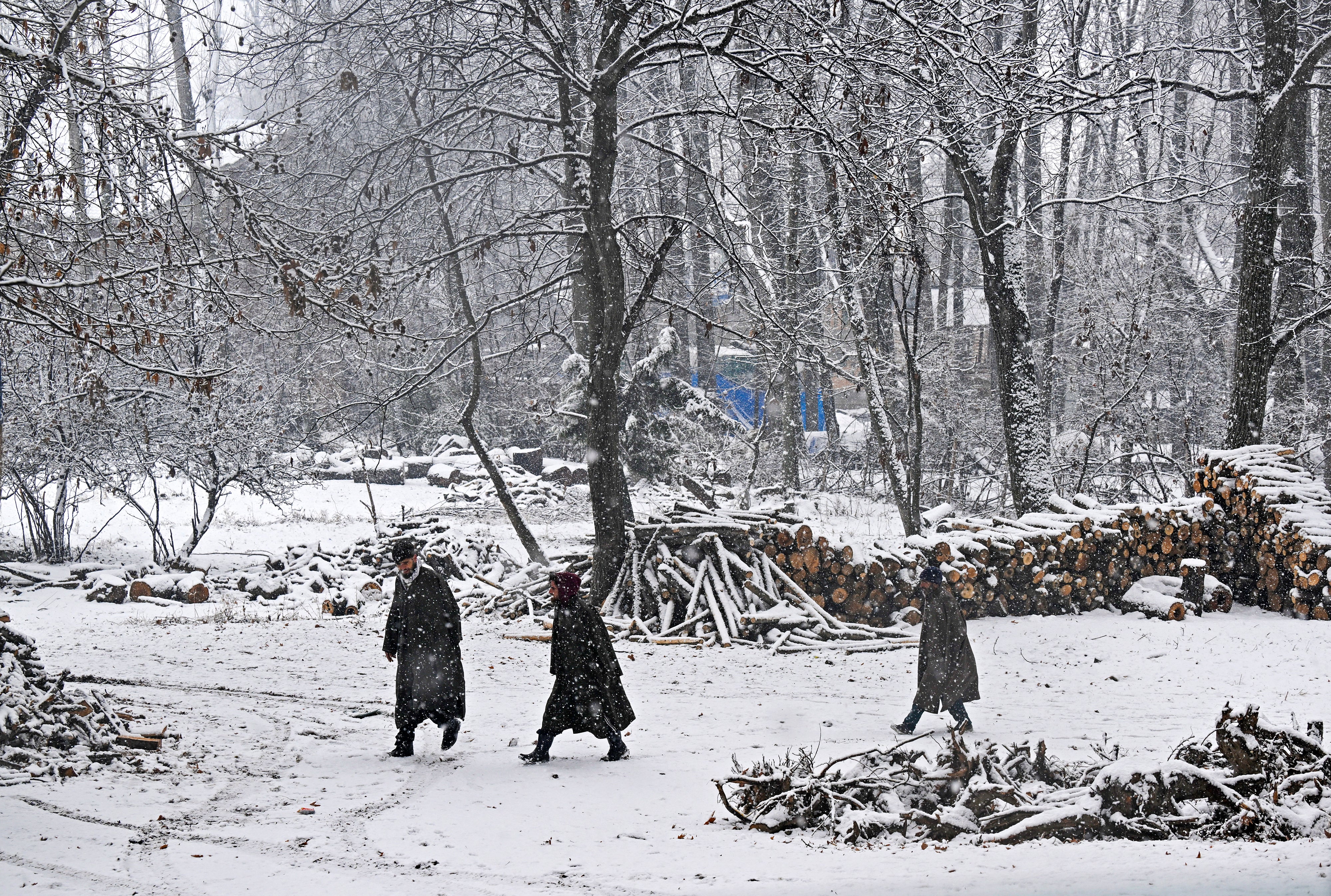 People walk amid snowfall in Anantnag, Jammu and Kashmir on 16 January 2025