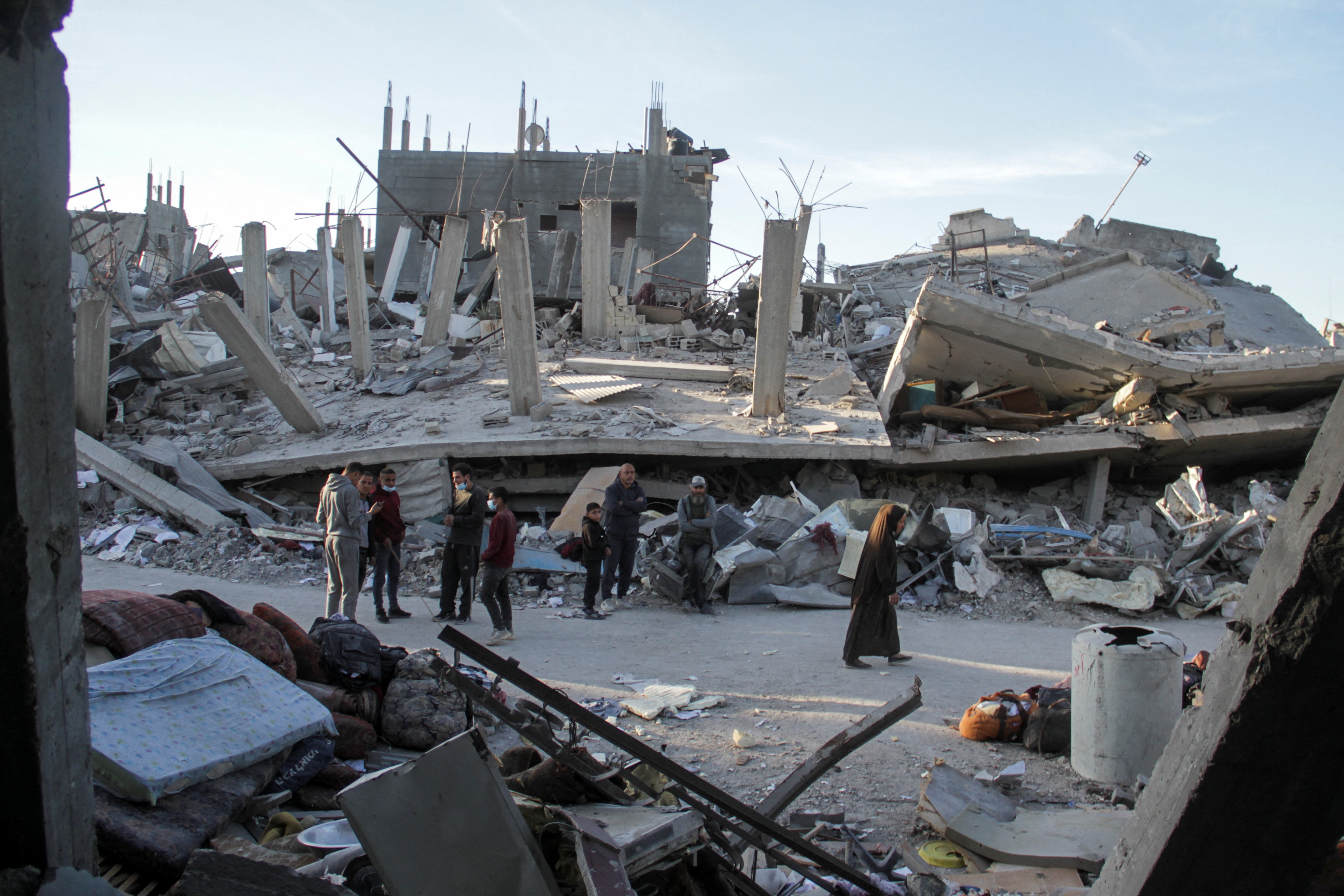 Palestinians stand near destroyed homes, amid a ceasefire between Israel and Hamas, in Jabalia Refugee Camp