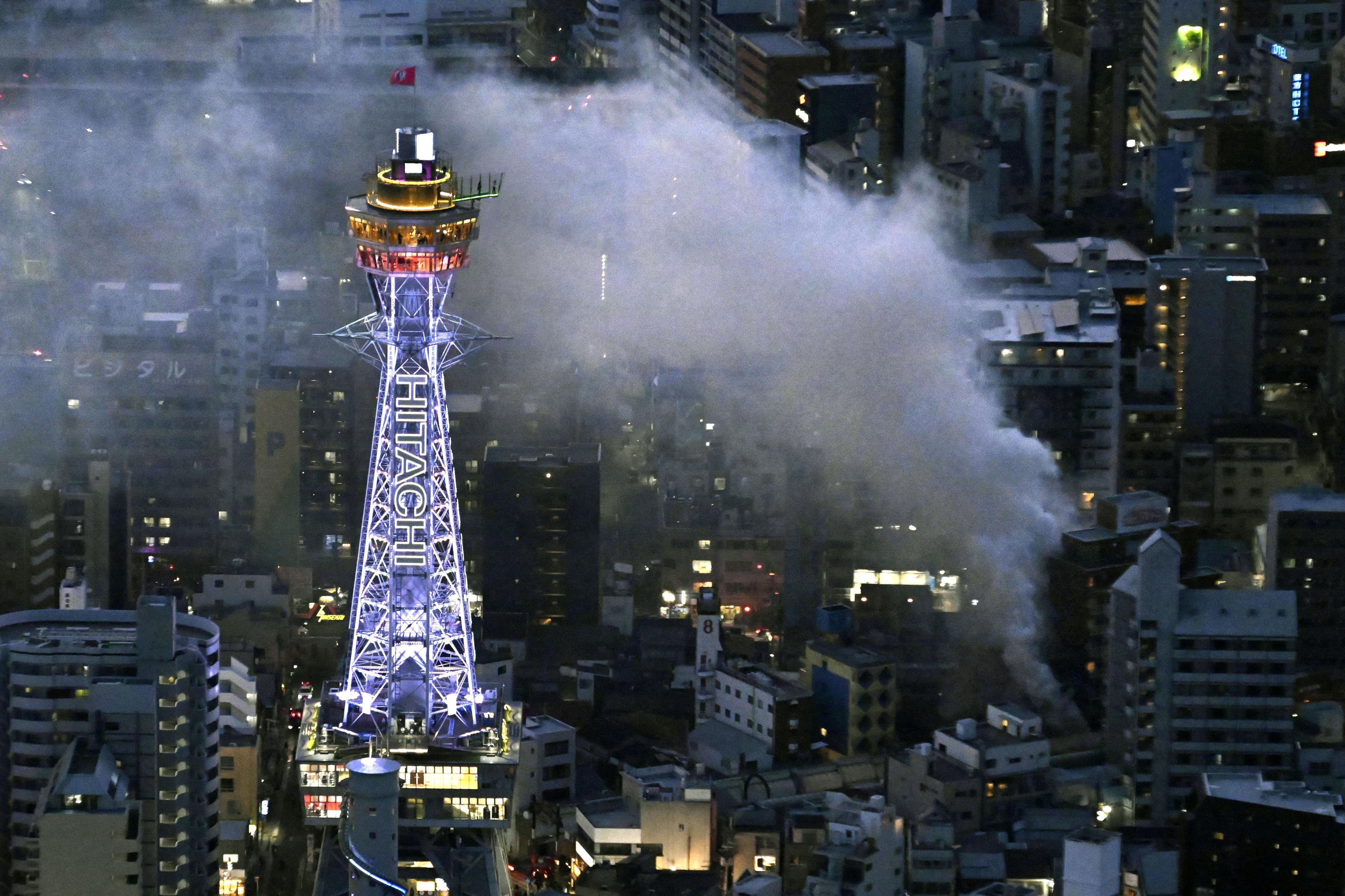 <p>An aerial view shows smoke rising from a fire site at a commercial building near a famous tourist landmark Tsutenkaku Tower, in Osaka, Japan January 21, 2025</p>