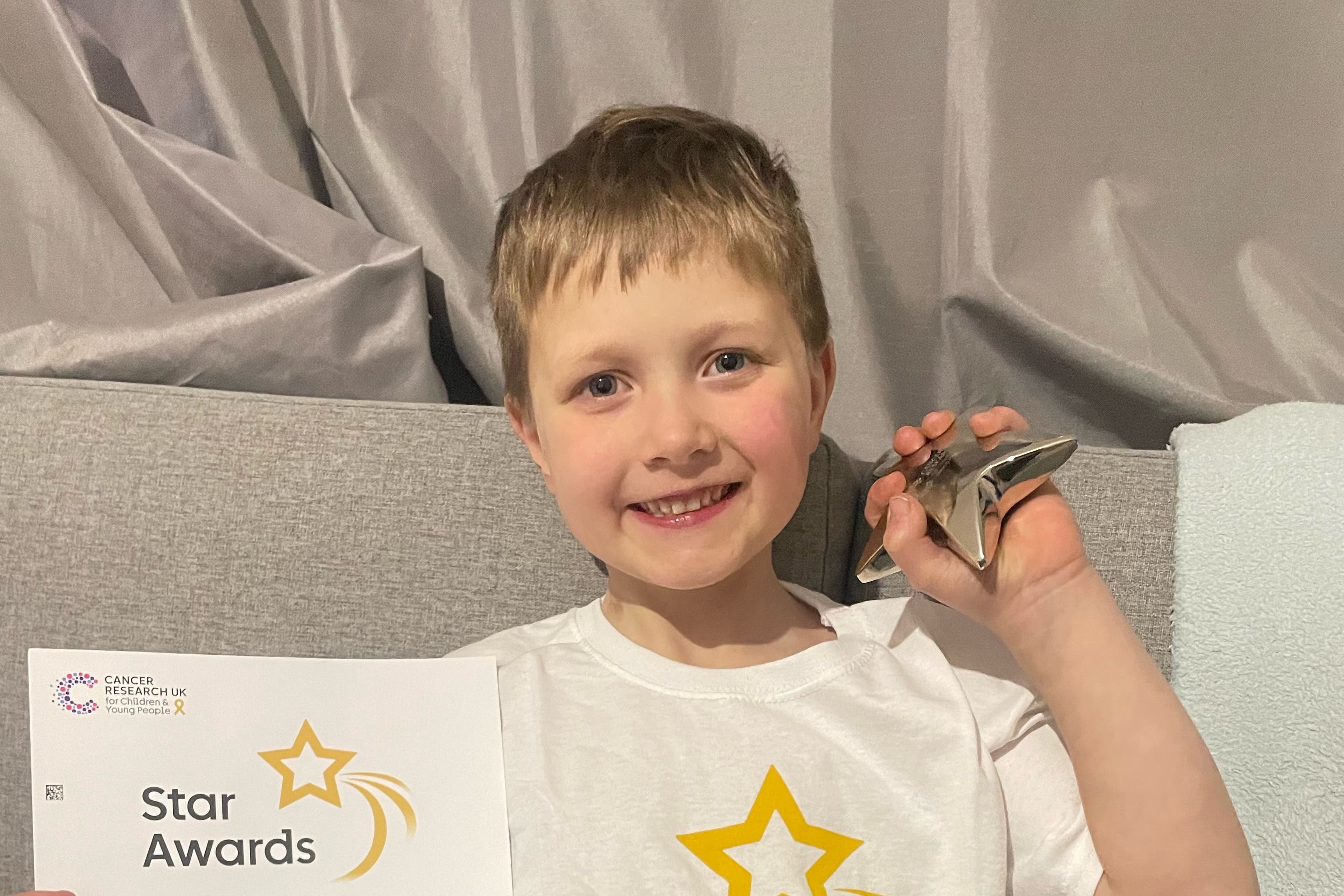 Isaac Perry, six, with his Cancer Research UK Star Award (Cancer Research UK/PA)
