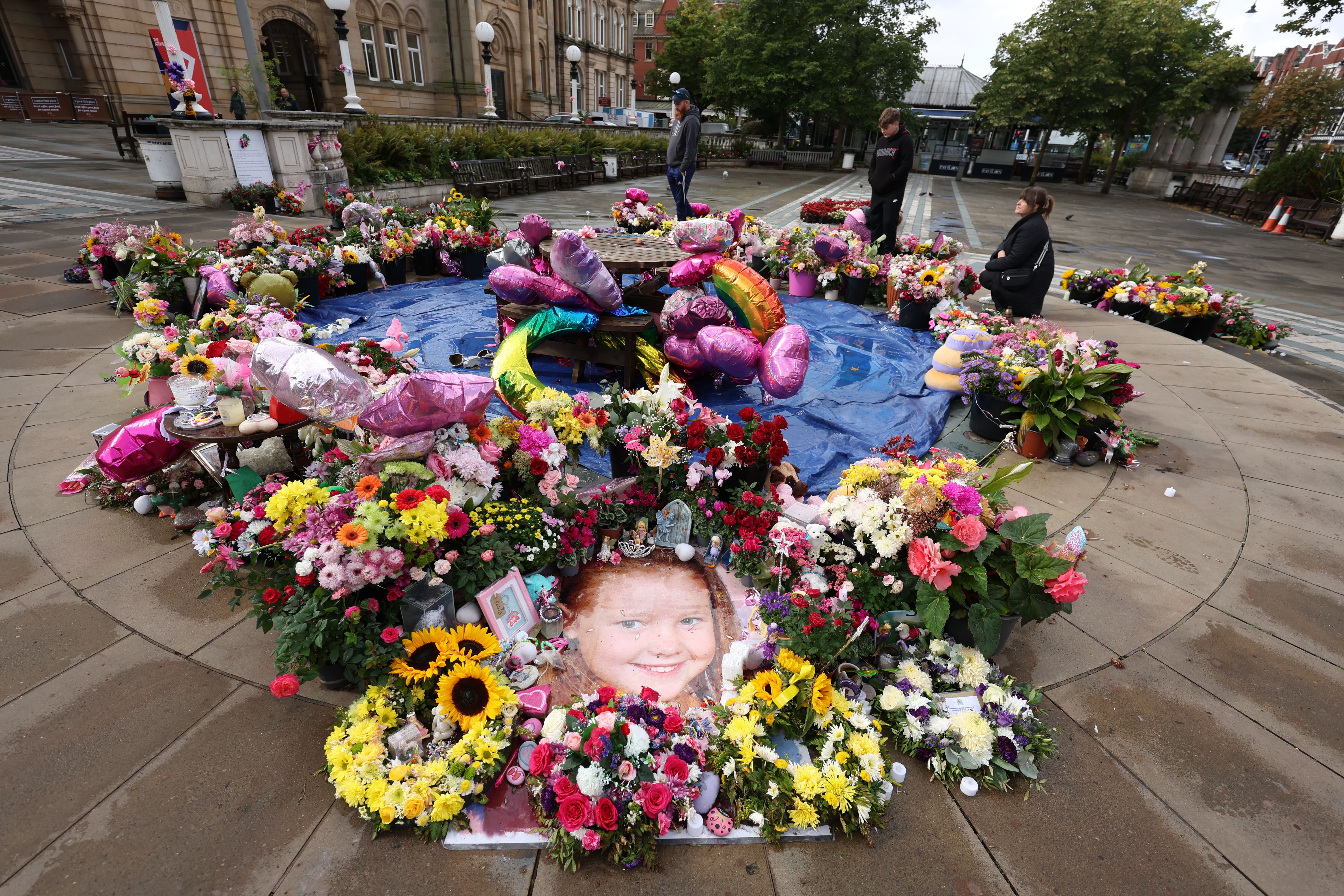 A photo of Elsie Dot Stancombe among the flowers and tributes outside the Atkinson Art Centre in Southport