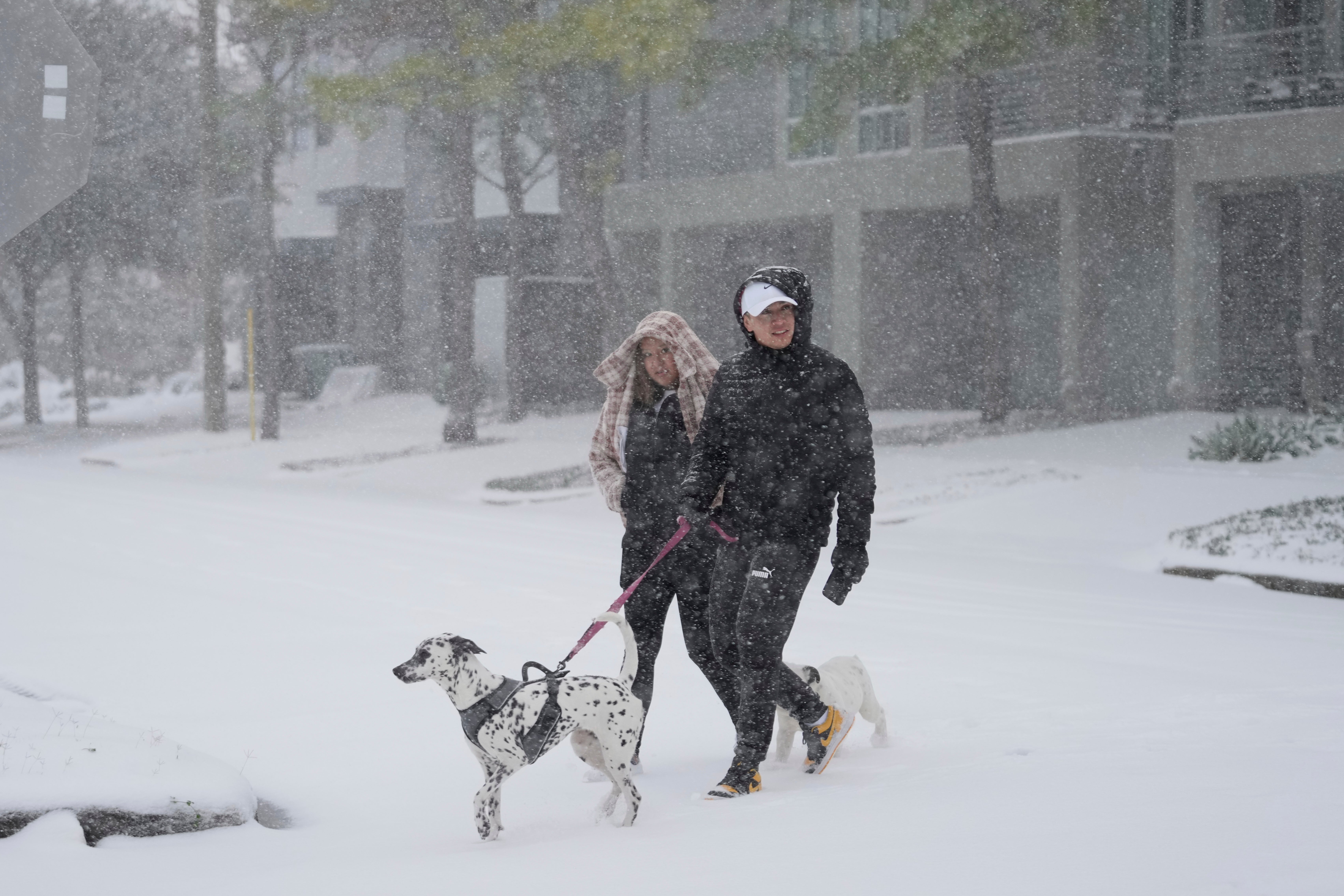 People take a walk in the neighborhood on Tuesday in Houston, Texas. The city is hosting an update with officials on Tuesday night