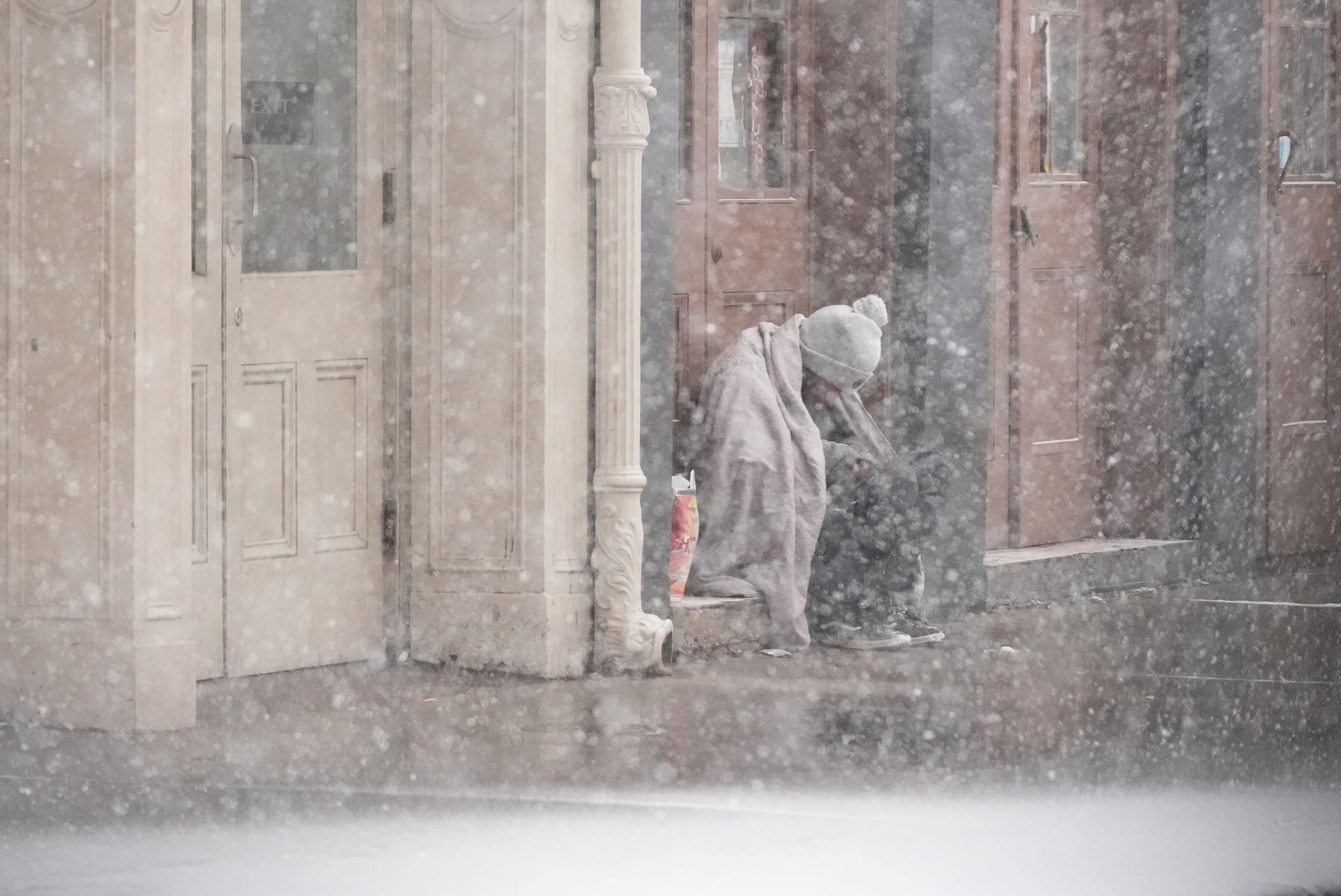 A homeless man sits in a doorway on Tuesday as snow falls in New Orleans, Louisiana. The heaviest snow was forecast to begin by late morning