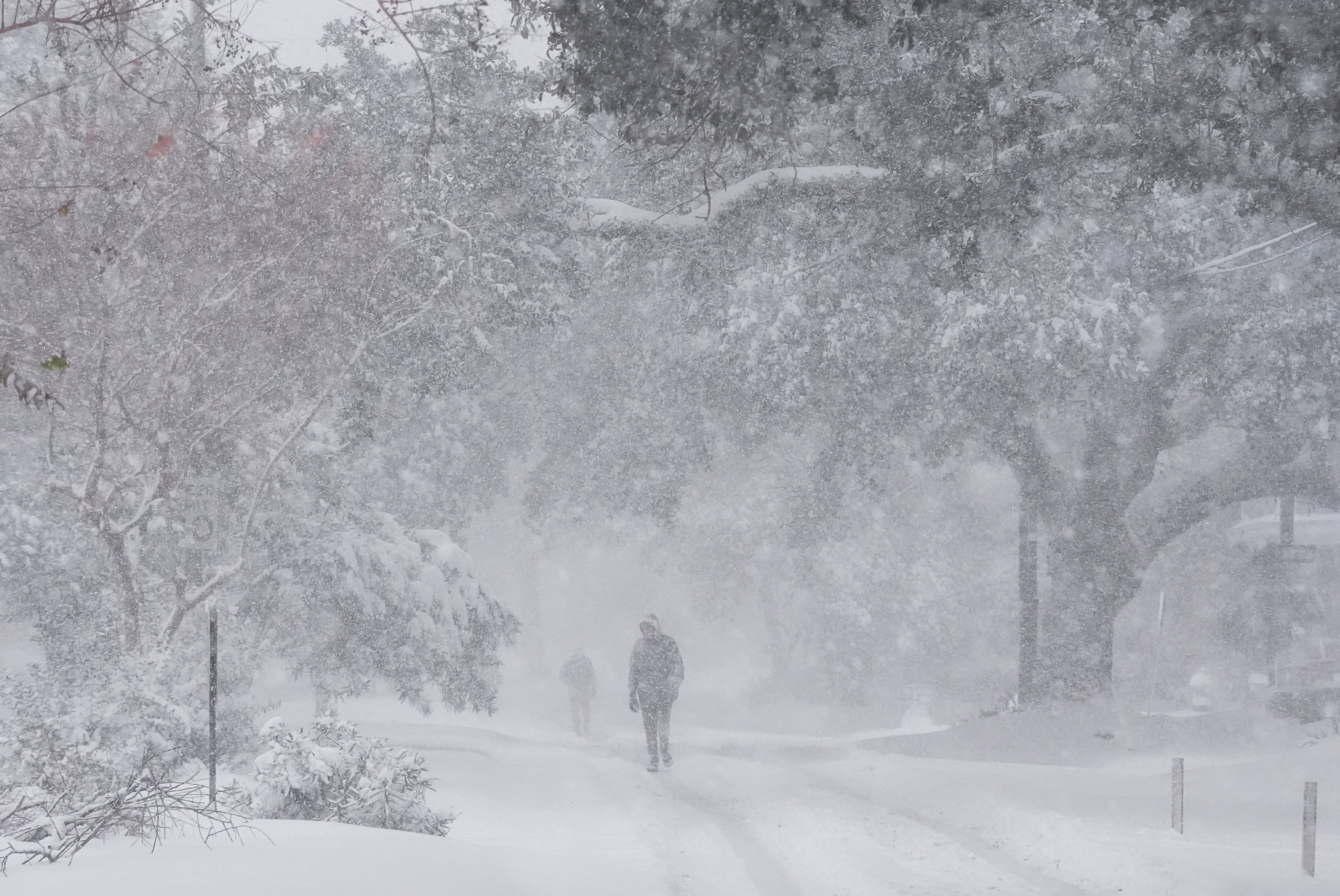 People walk as snow falls in New Orleans, Louisiana, on Tuesday. A rare and impactful storm brought inches of snow to the Southeast