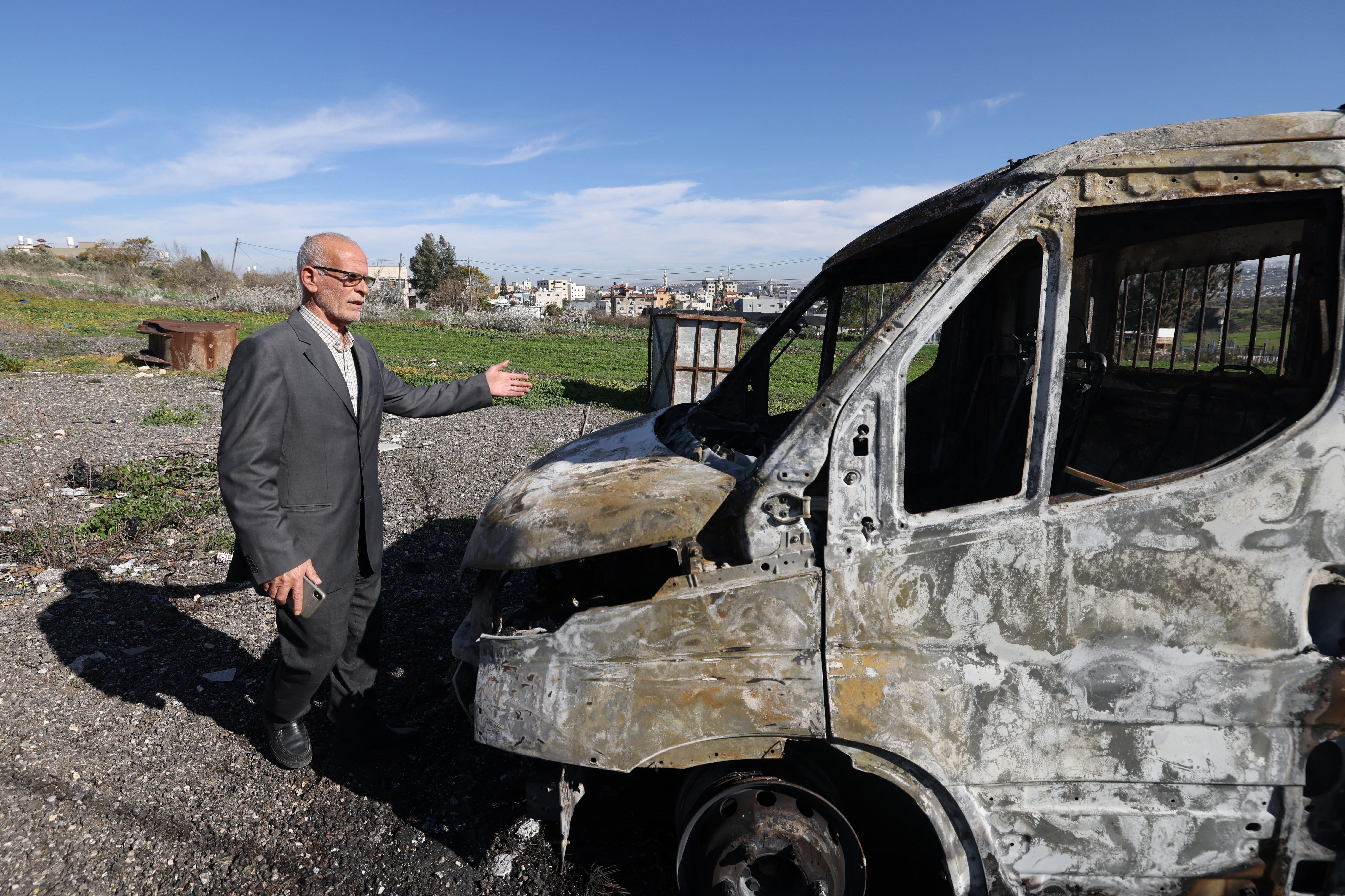 A Palestinian man checks the site of an attack by Israeli settlers in the Palestinian village of Jinsafut in the north of the occupied West Bank, on 21 January 2025