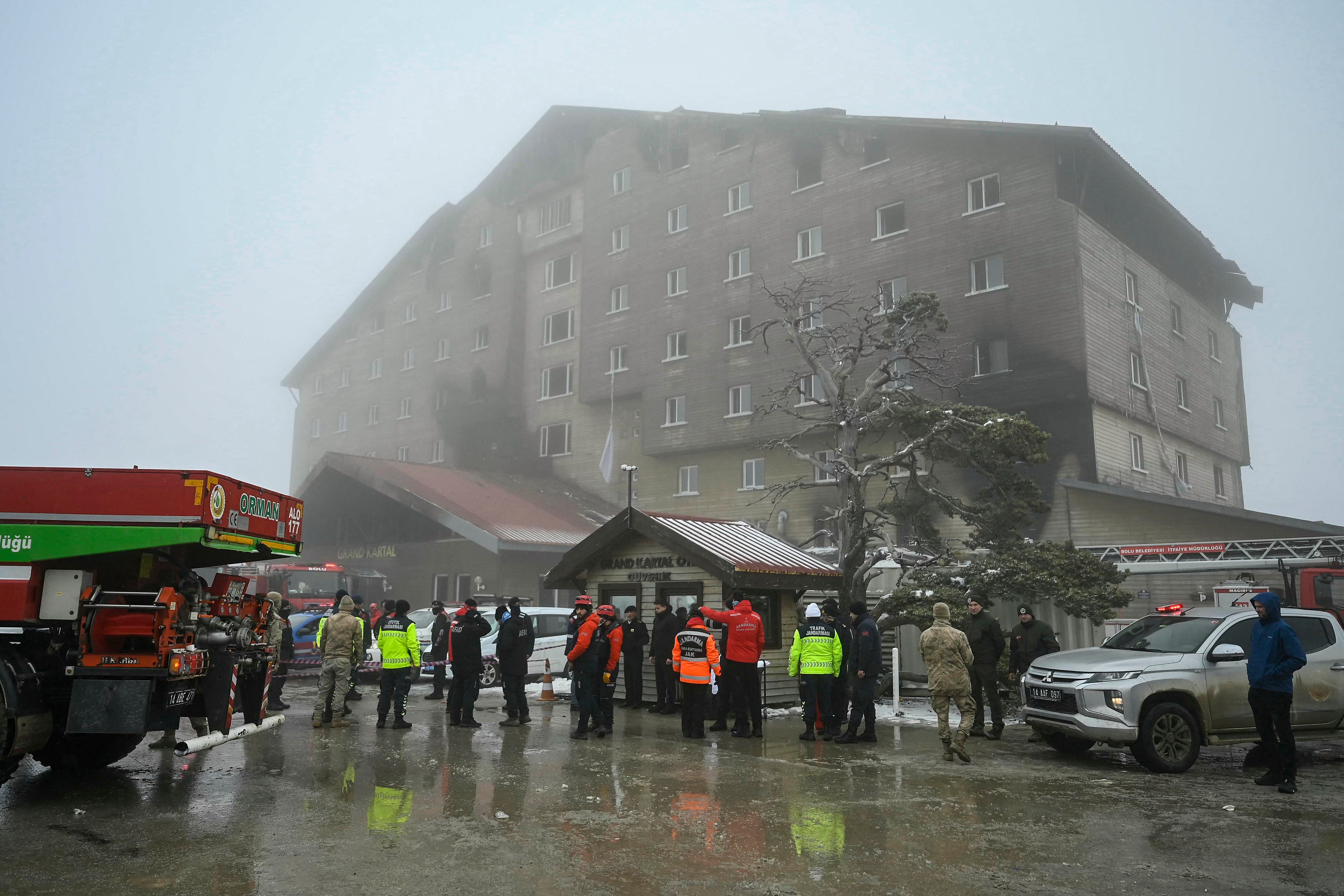 Turkish emergency personnel stand by the aftermath of the fire that broke out in the hotel