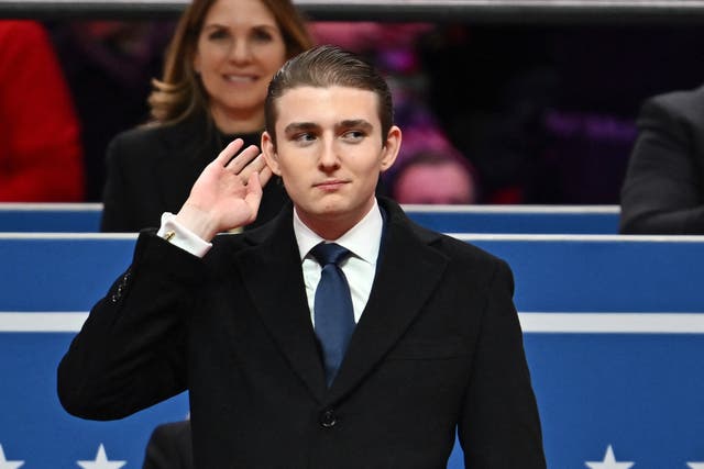 <p>Barron Trump gestures after being acknowledged by his father US President Donald Trump during the inaugural parade. A classmate and president of NYU’s College Republicans called the first son an ‘oddity’ — a week later, she resigned</p>