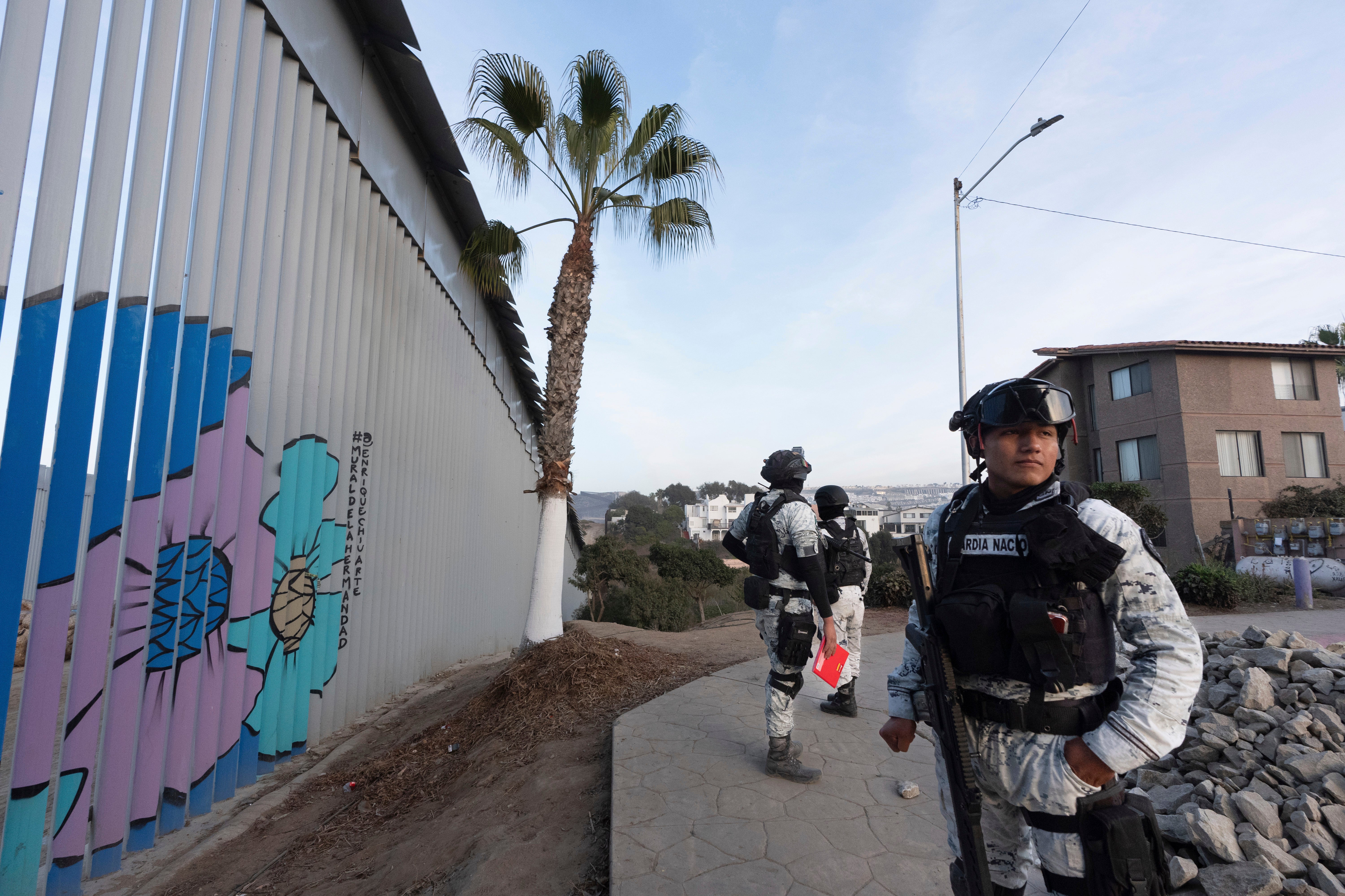 Members of the Mexican National Guard patrol along the border wall separating Mexico and the United States. More than 2,000 U.S. troops are already at the border to help slow migrants entering the U.S.