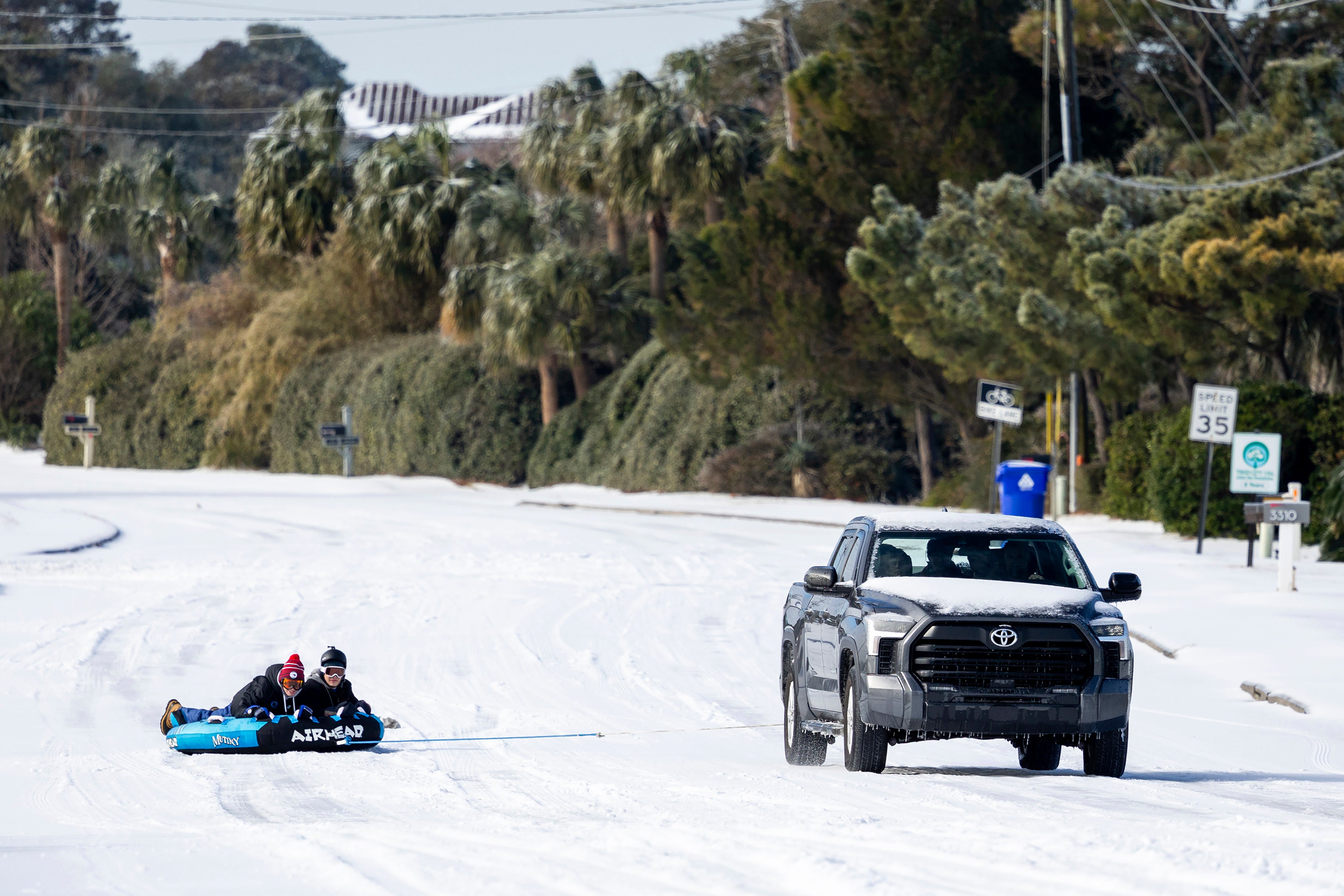 People take advantage of the snow on the H.L. Hunley bridge after a winter storm dropped ice and snow Wednesday on the Isle of Palms, South Carolina. Freezing rain also fell in the state