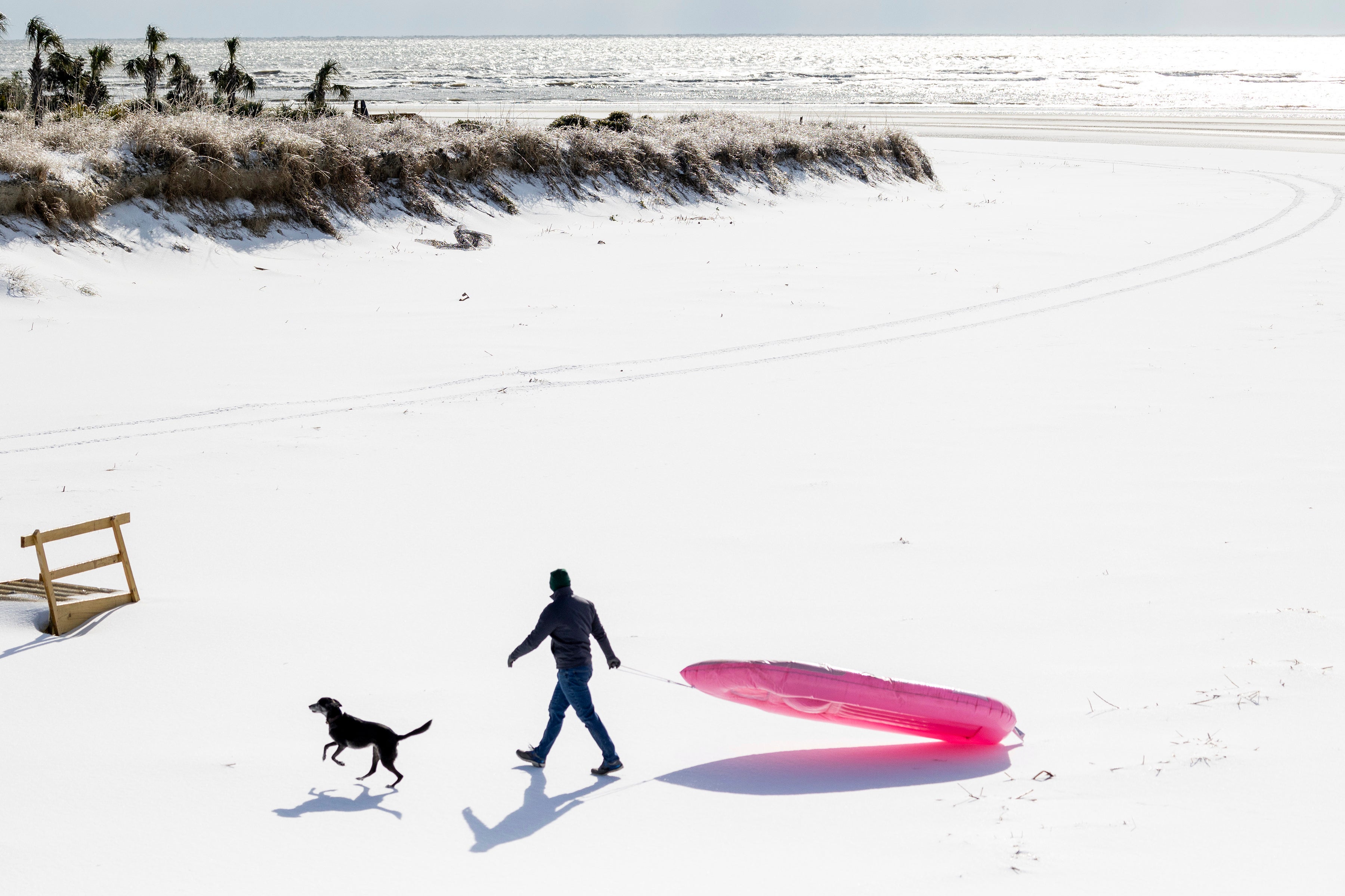 A man and his dog enjoy the beach after a winter storm dropped ice and snow on Wednesday on the Isle of Palms, South Carolina. More than 5 inches of snow were reported in the state