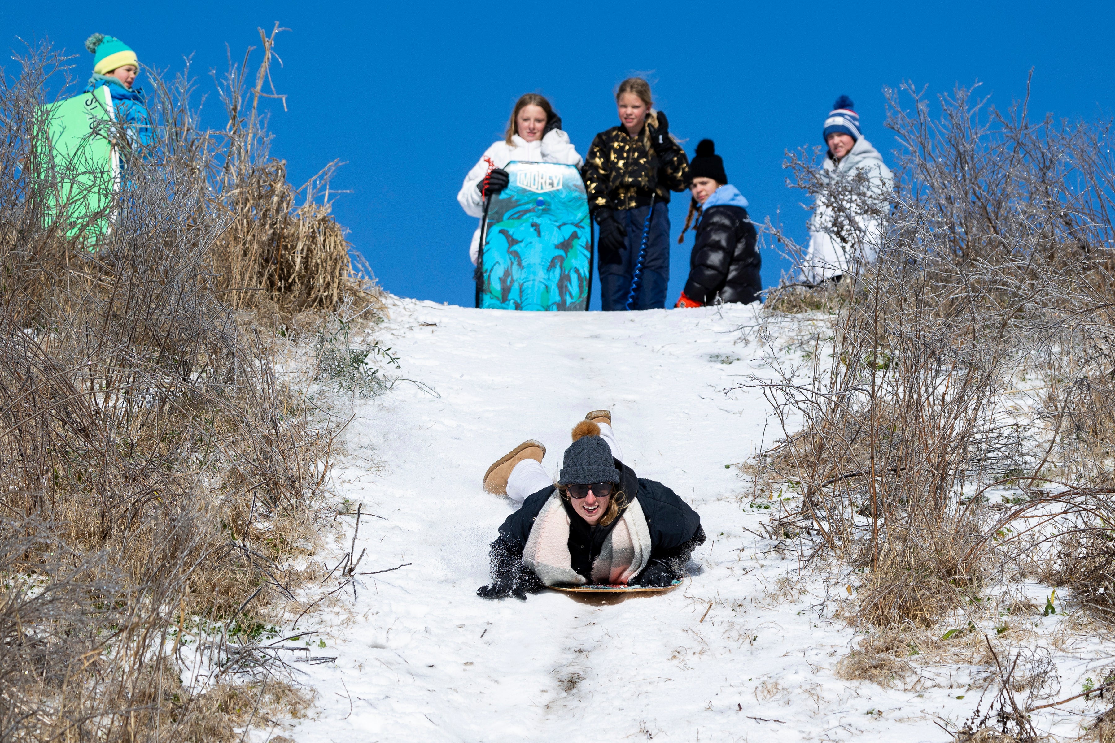 People enjoy the snow after a winter storm dropped ice and snow Wednesday on Sullivan's Island, South Carolina. Shower blanketed the states’s coast