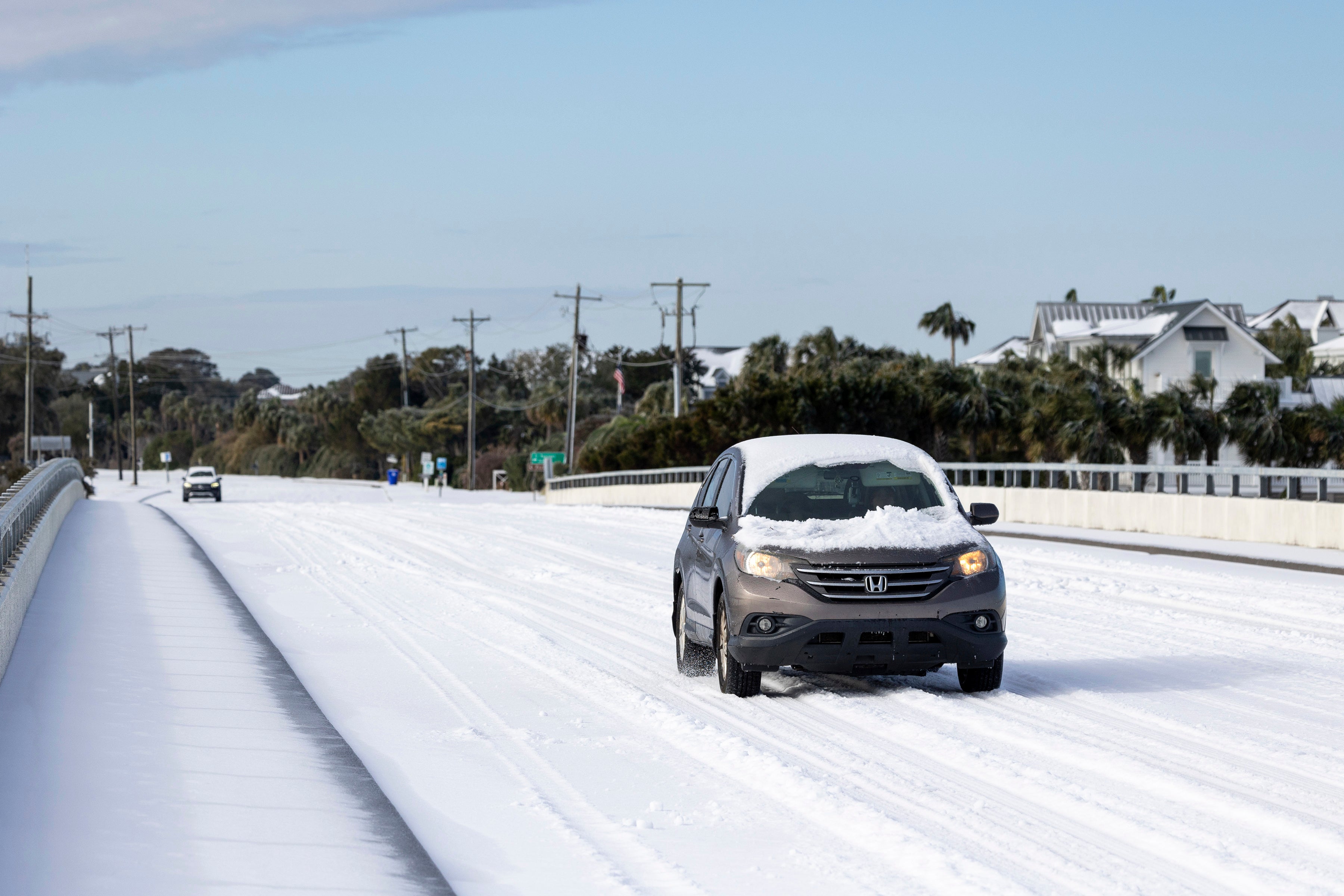 A car drives across the H.L. Hunley bridge after a winter storm dropped ice and snow on Wednesday on the Isle of Palms, South Carolina. The Carolinas were the latest states to be affected by the storm