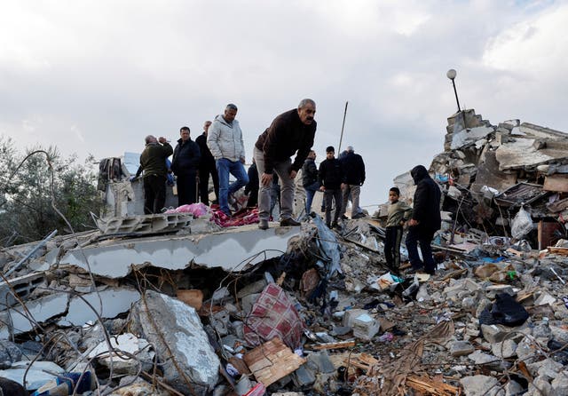 <p>Palestinians gather near damaged property after two Palestinian gunmen were killed in an Israeli raid</p>