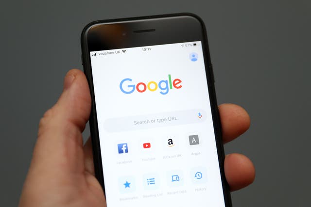 A person holds an iphone showing the app for Google chrome search engine (Andrew Matthews/PA)