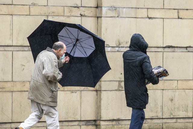 A man in Belfast struggles with his umbrella 21 (Liam McBurney/PA)