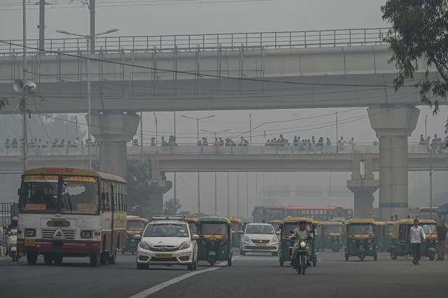 <p>Commuters make their way along a street amid smoggy conditions in New Delhi</p>