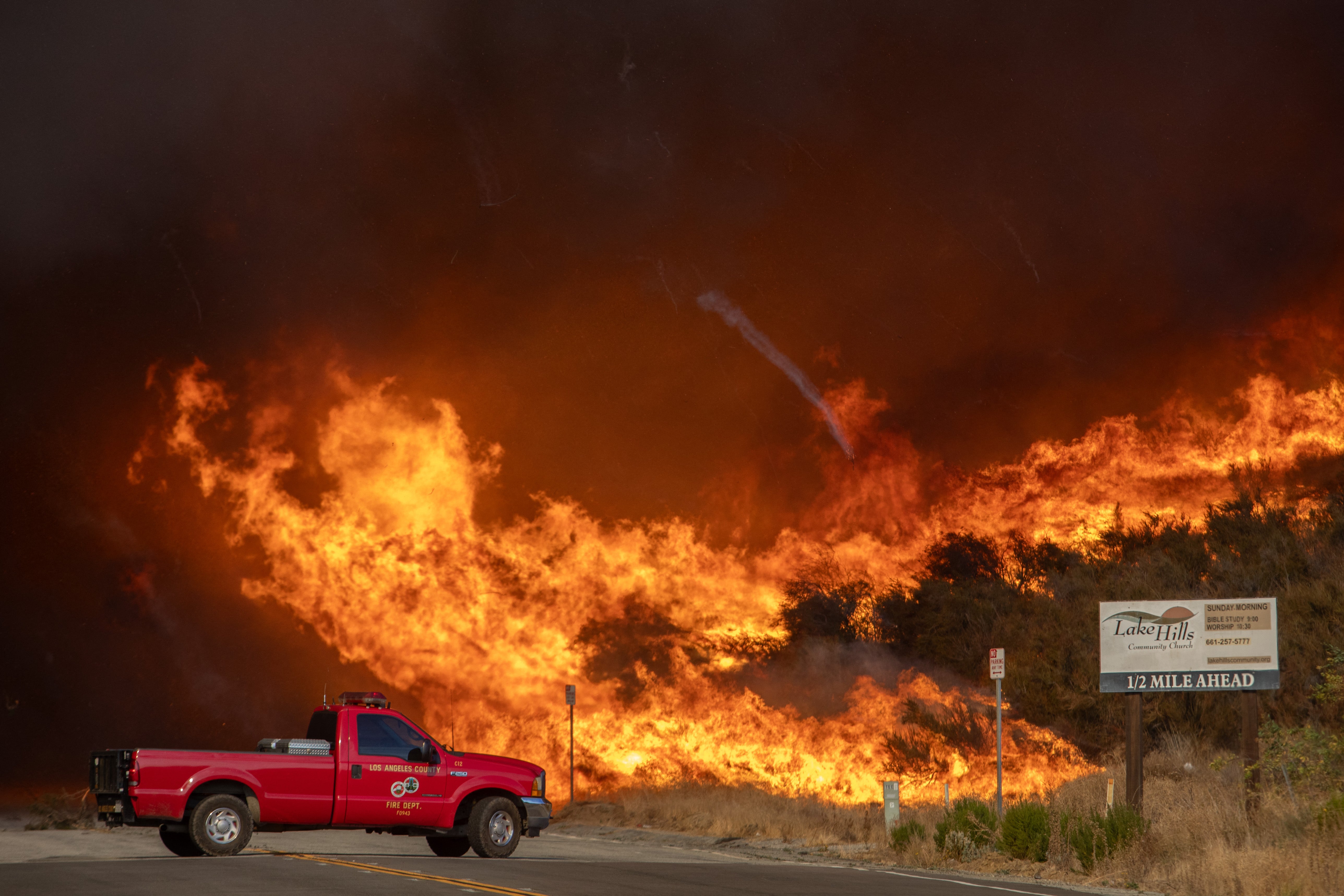 A firefighter truck backs up amid flames from the Hughes Fire in Castaic, California, on Wednesday. The fire has not spread on Thursday