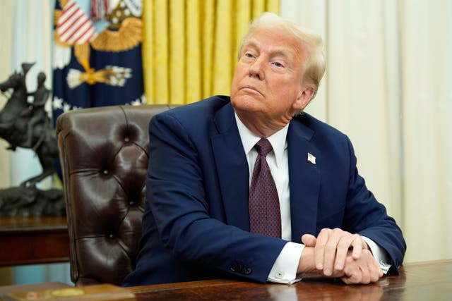 <p>President Donald Trump sits in the Oval Office after signing executive orders. Young lawyers have been informed that their offers for the Attorney General’s Honors Program were revoked due to a new federal hiring freeze, according to a report </p>