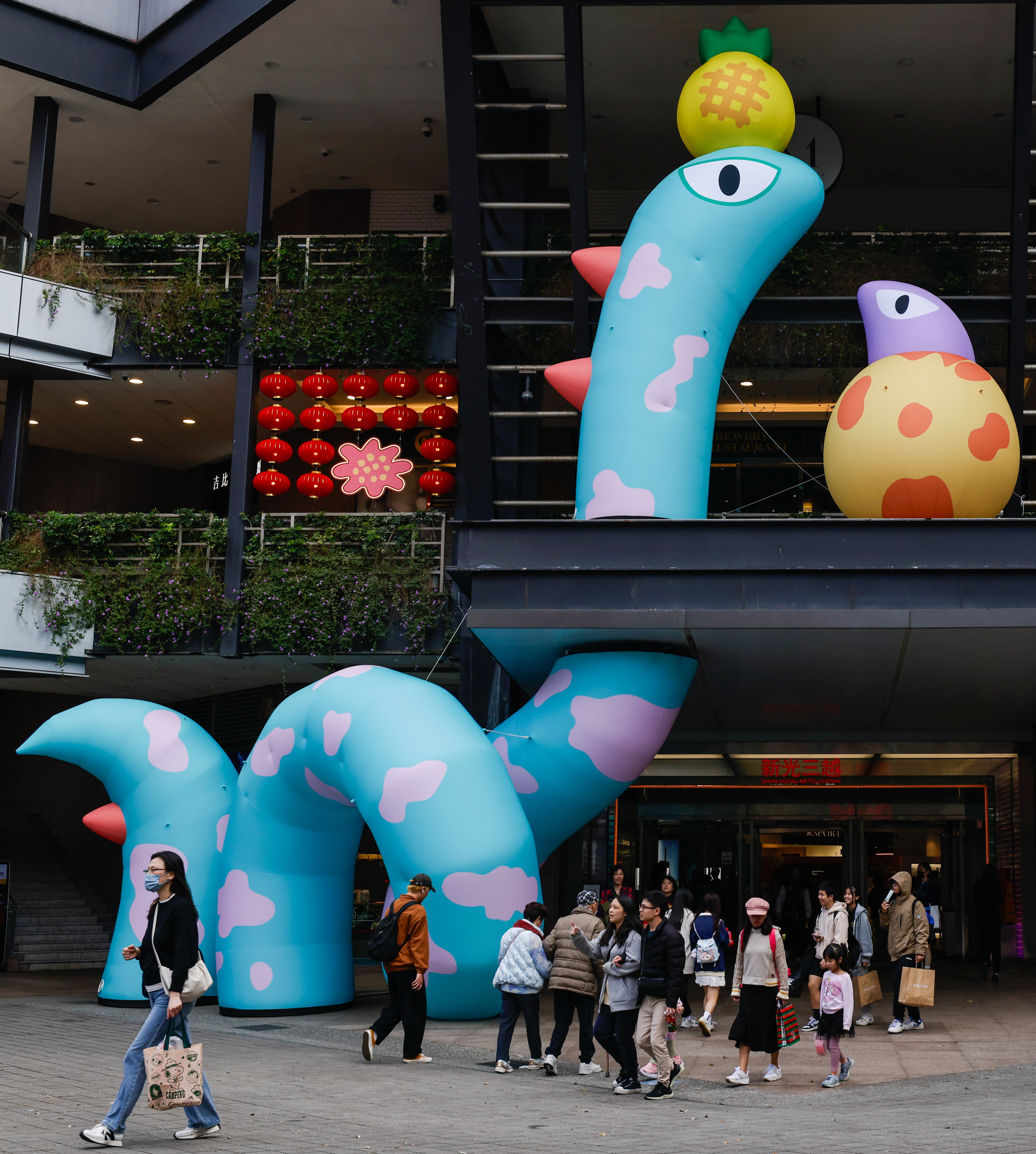 People walk under a snake figure installation for lunar new year decoration in Taipei, Taiwan, 24 January 2025