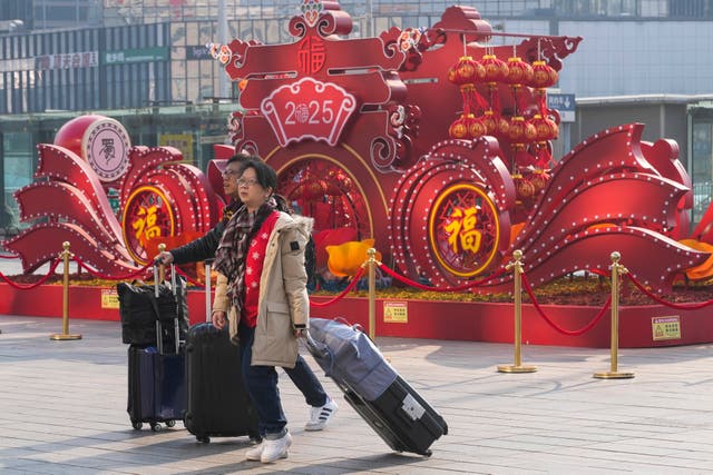 <p>Travelers walk towards the departure hall to catch their trains at the Beijing West Railway Station ahead of the Lunar New Year in Beijing on Friday, Jan. 24, 2025</p>