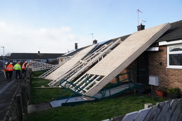 <p>A roof blown off during strong winds rests on some bungalows in Amble, Northumberland</p>