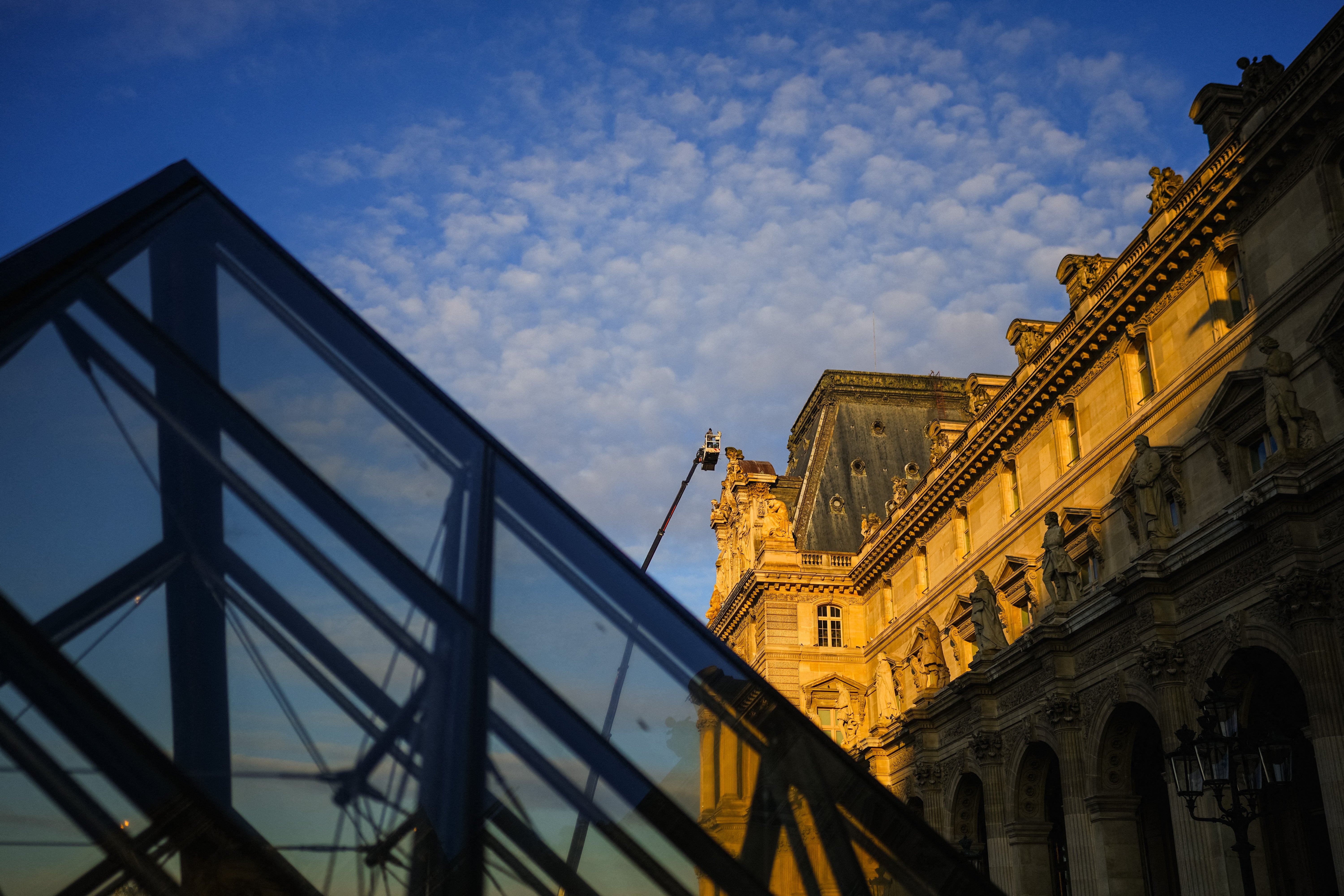 Trabalhadores limpam esculturas na fachada do Museu do Louvre, em Paris, em 23 de janeiro de 2025