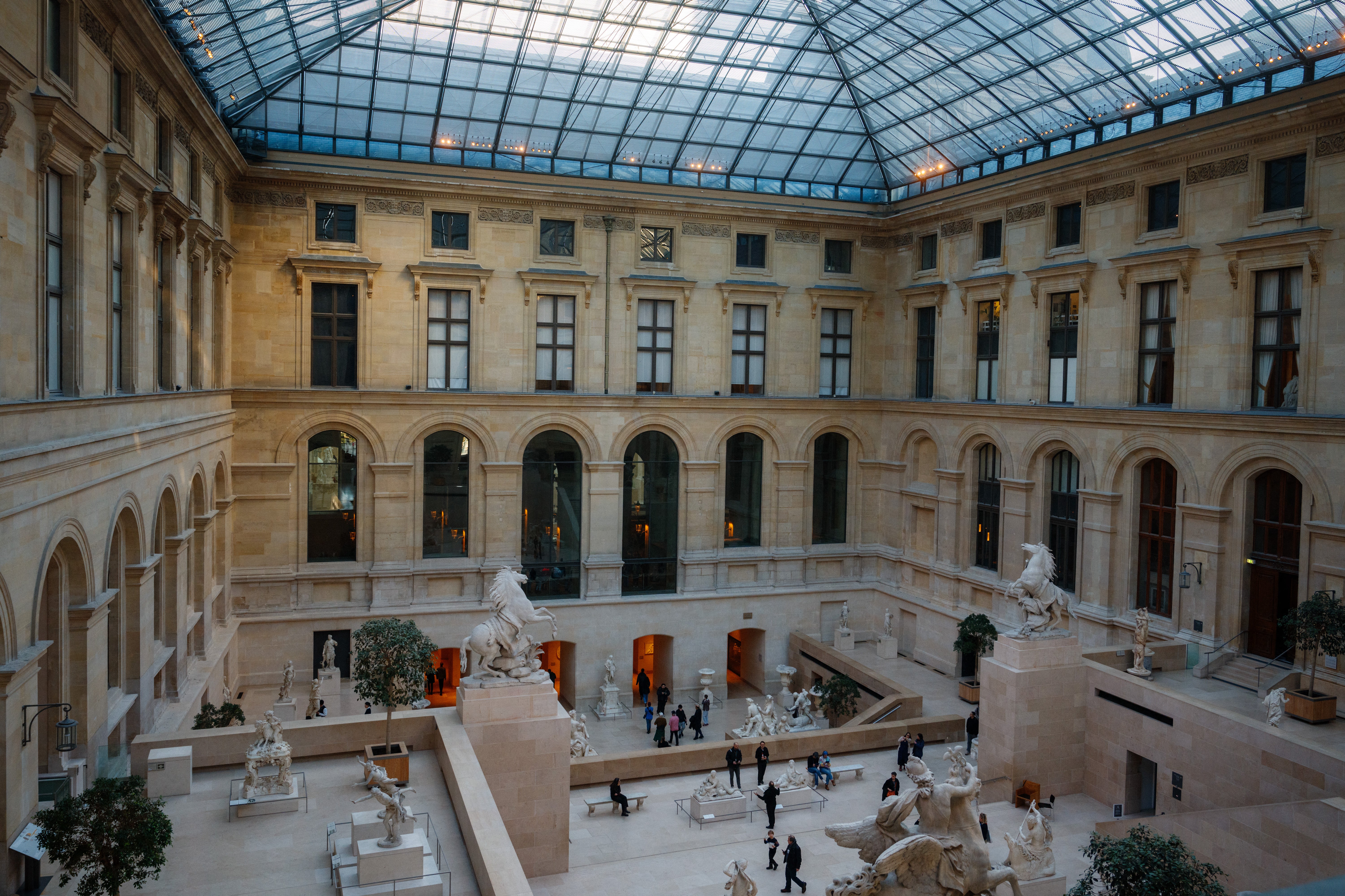 Visitors look at statues inside the Cour Marly at the Louvre Museum in Paris on January 23, 2025