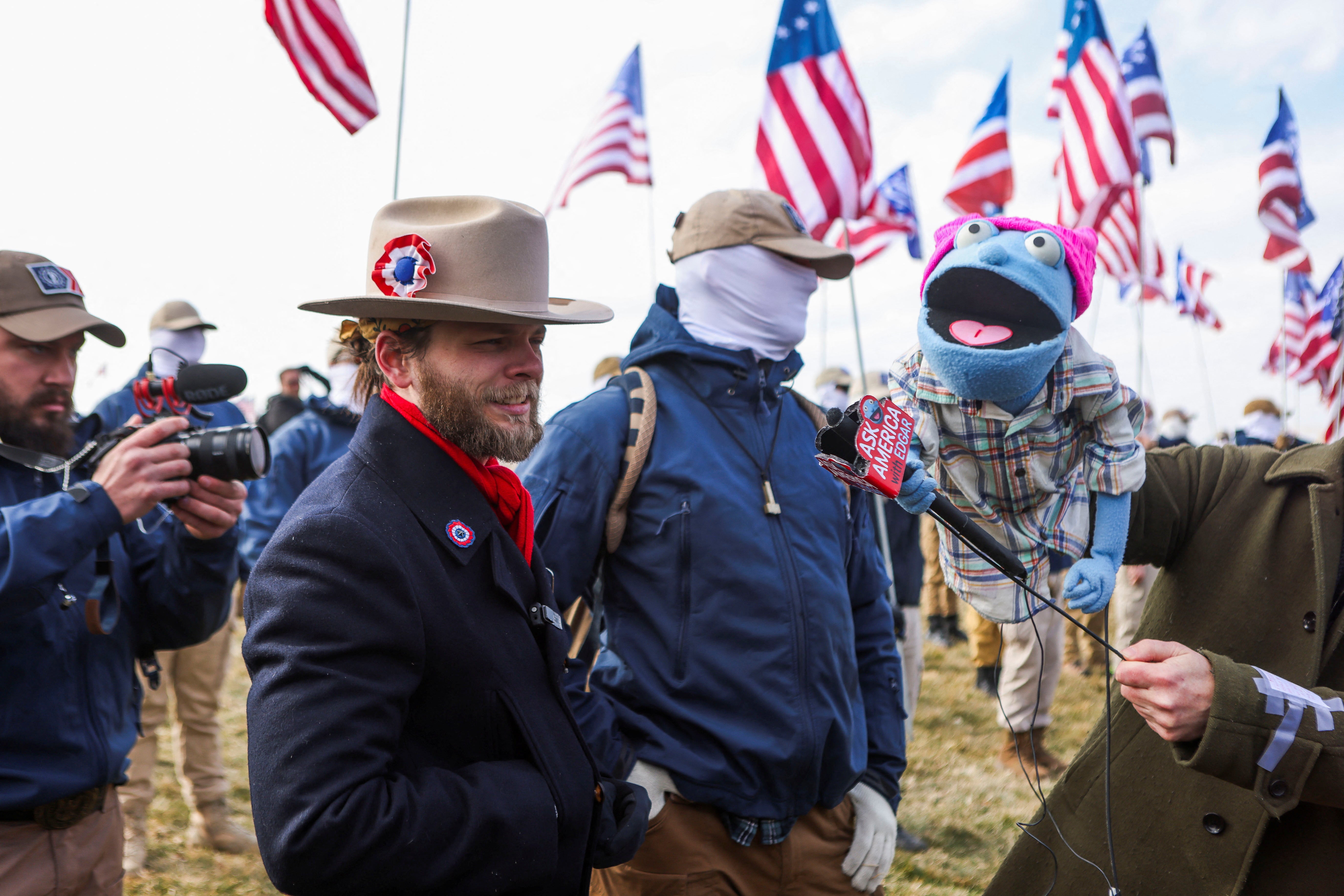 Thomas Ryan Rousseau, leader of Patriot Front, speaks during an interview next to a puppet