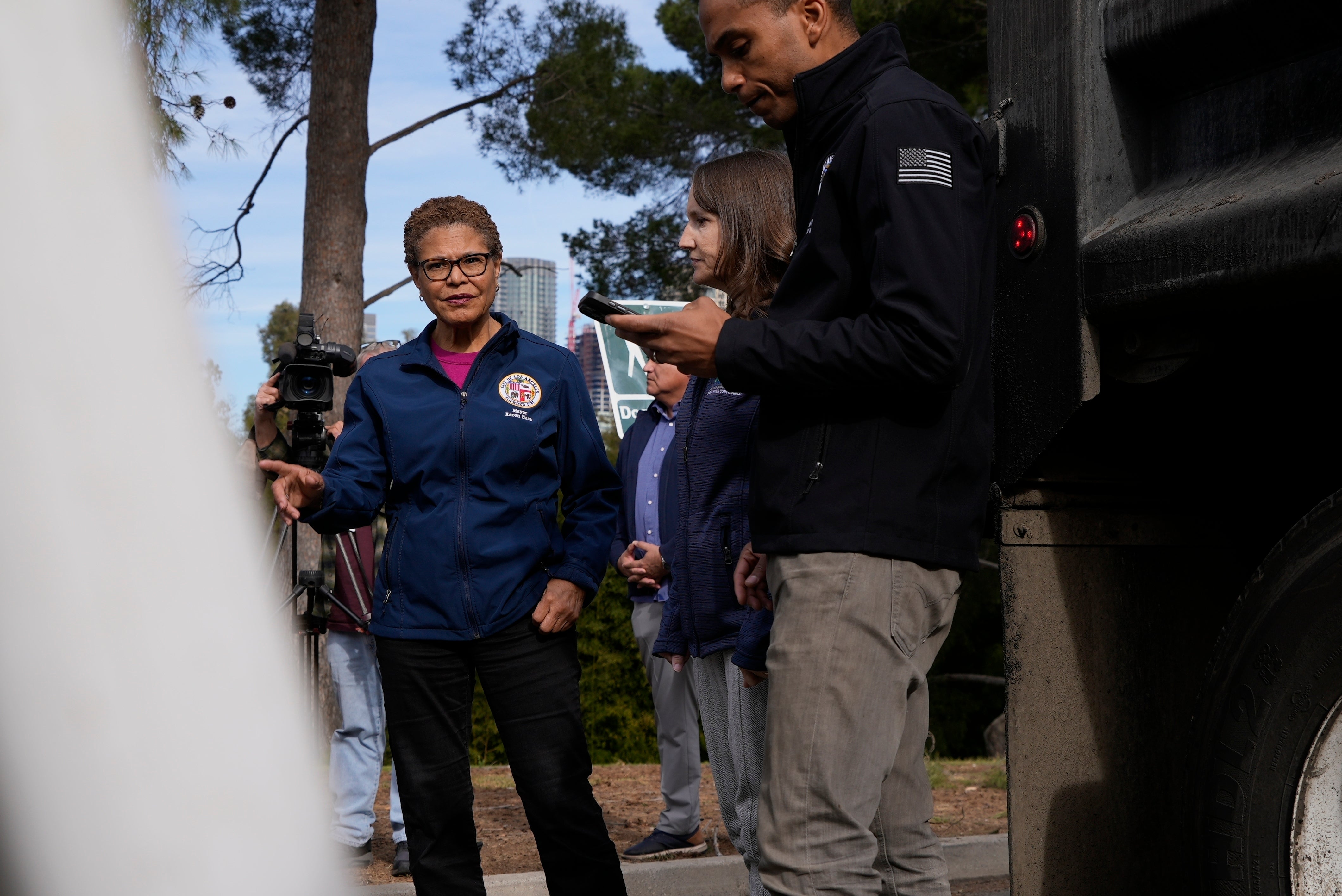 Los Angeles Mayor Karen Bass tours a staging area Wednesday in Los Angeles, California. City workers are preparing to reinforce burned land there ahead of rains expected this weekend