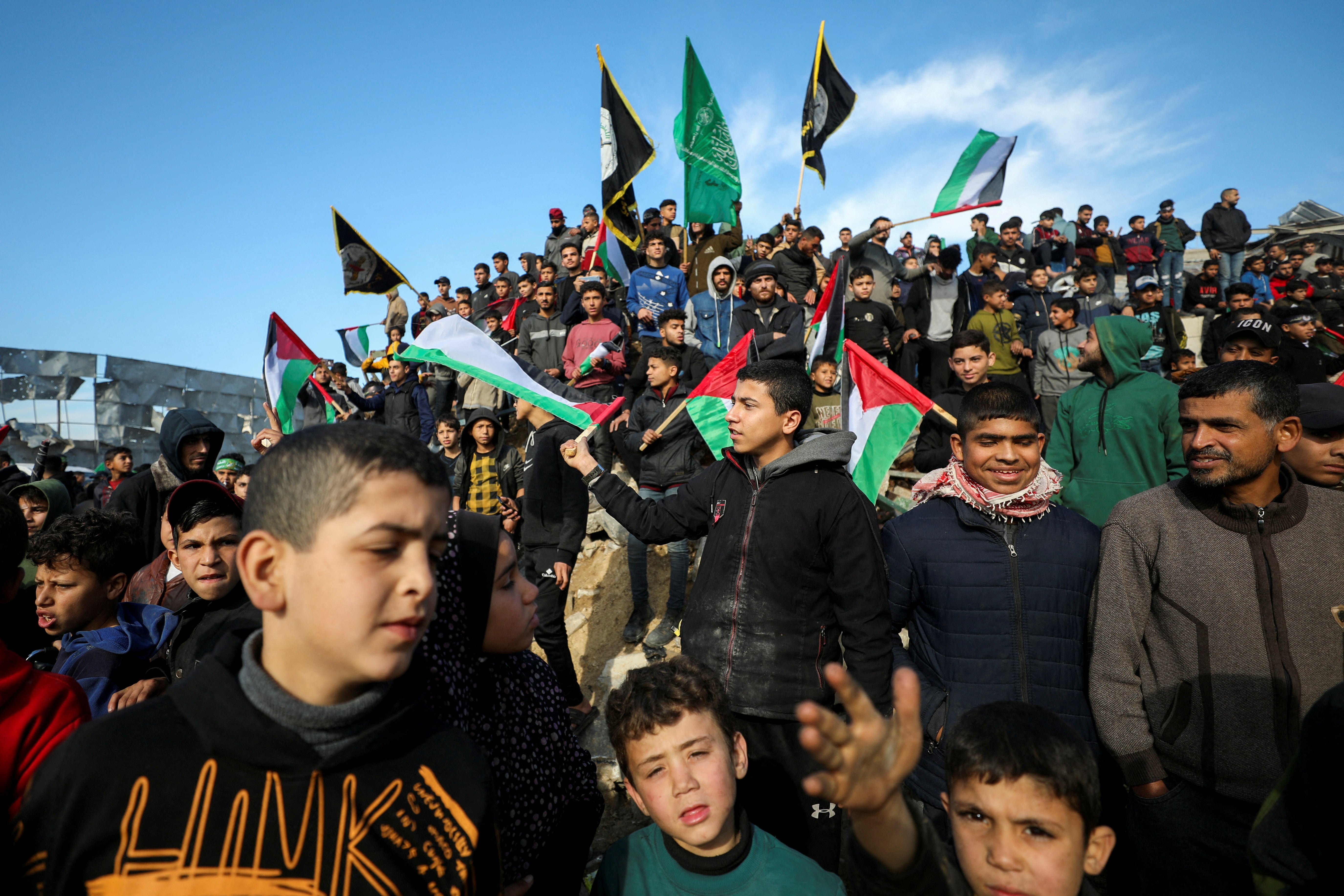 Palestinians gather before Hamas militants hand over the four hostages in Gaza City on Saturday